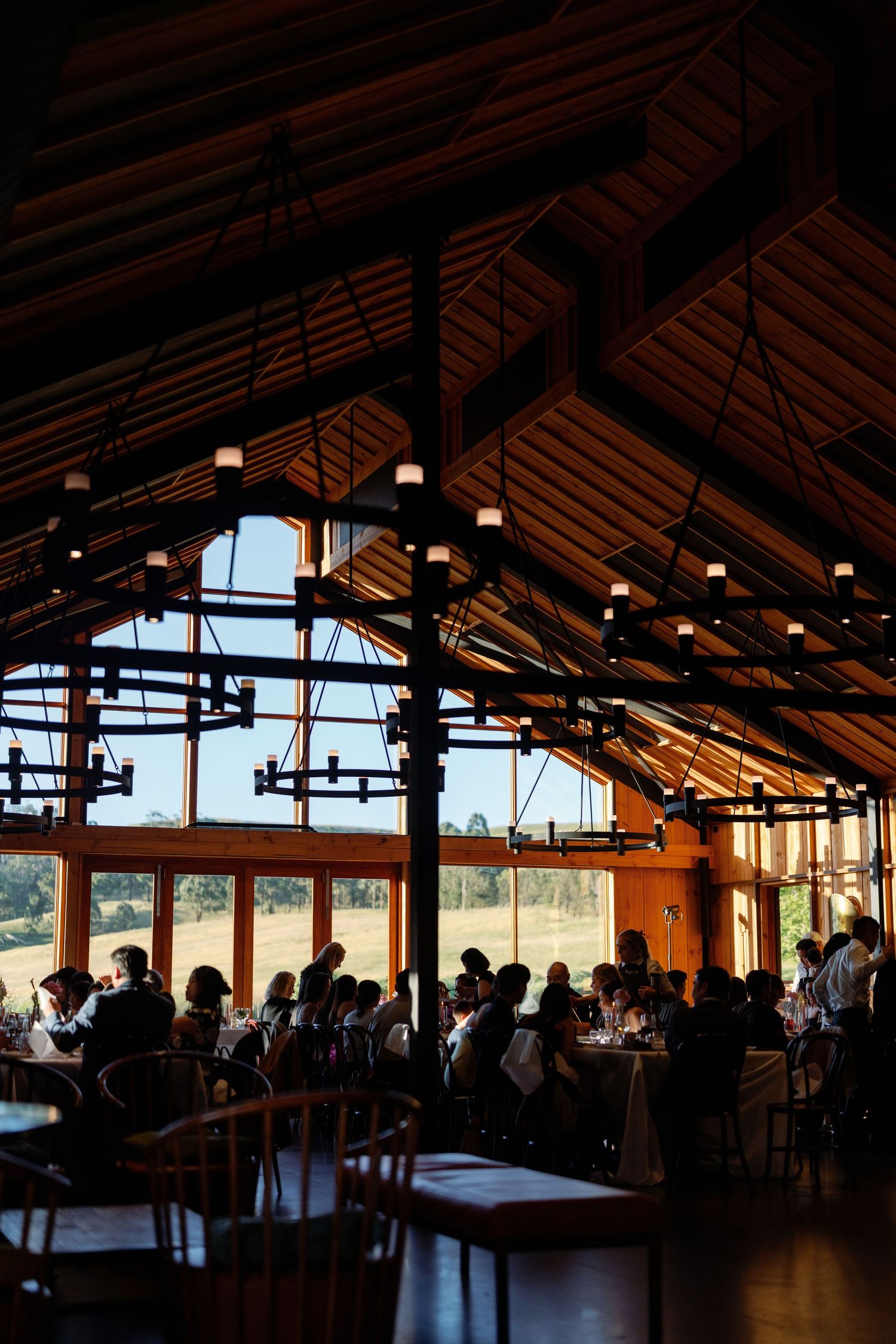 Large wooden event venue with panoramic windows and rustic architectural details.