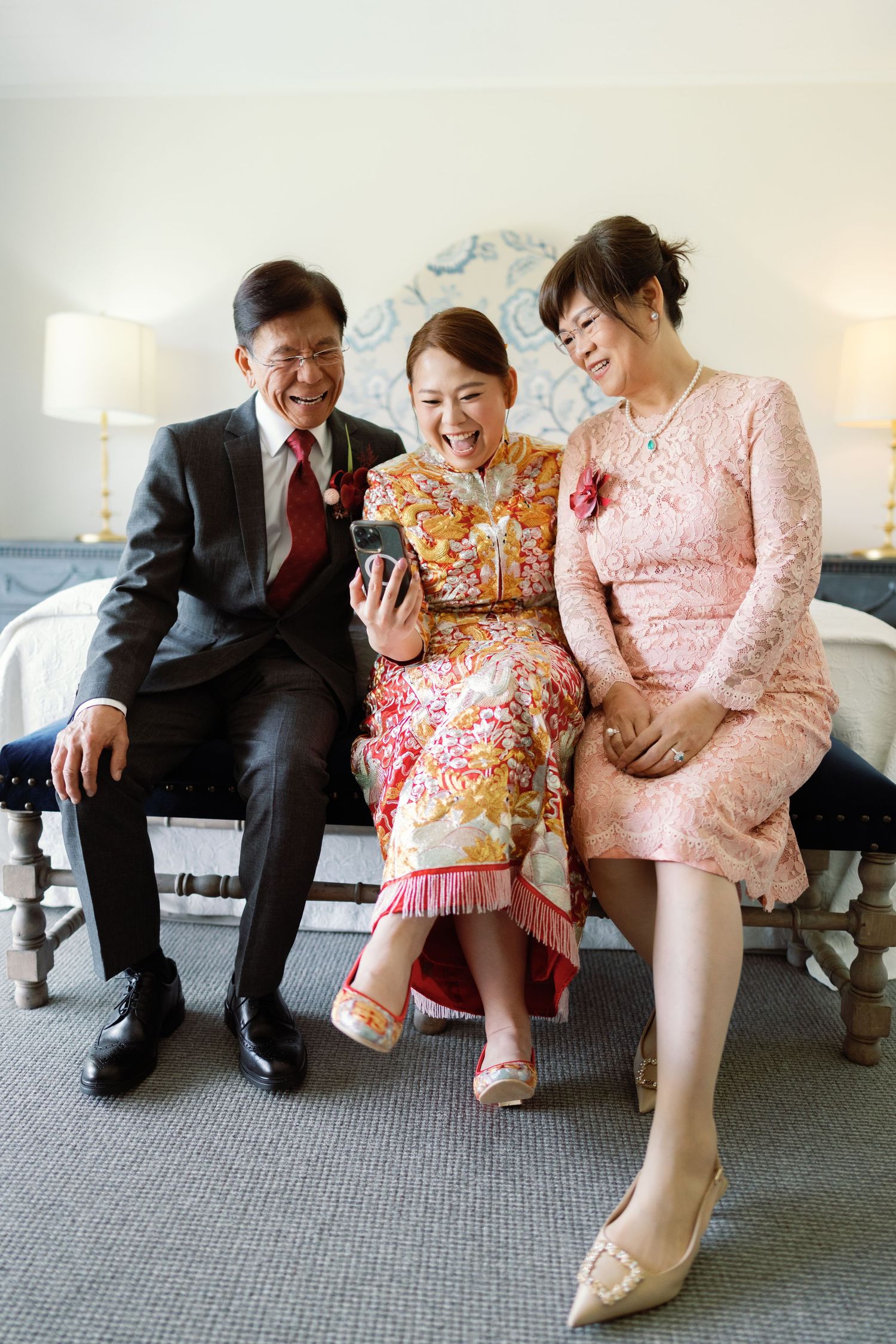 Candid moments showing wedding party members sitting on a couch in formal attire with pink and floral dresses.