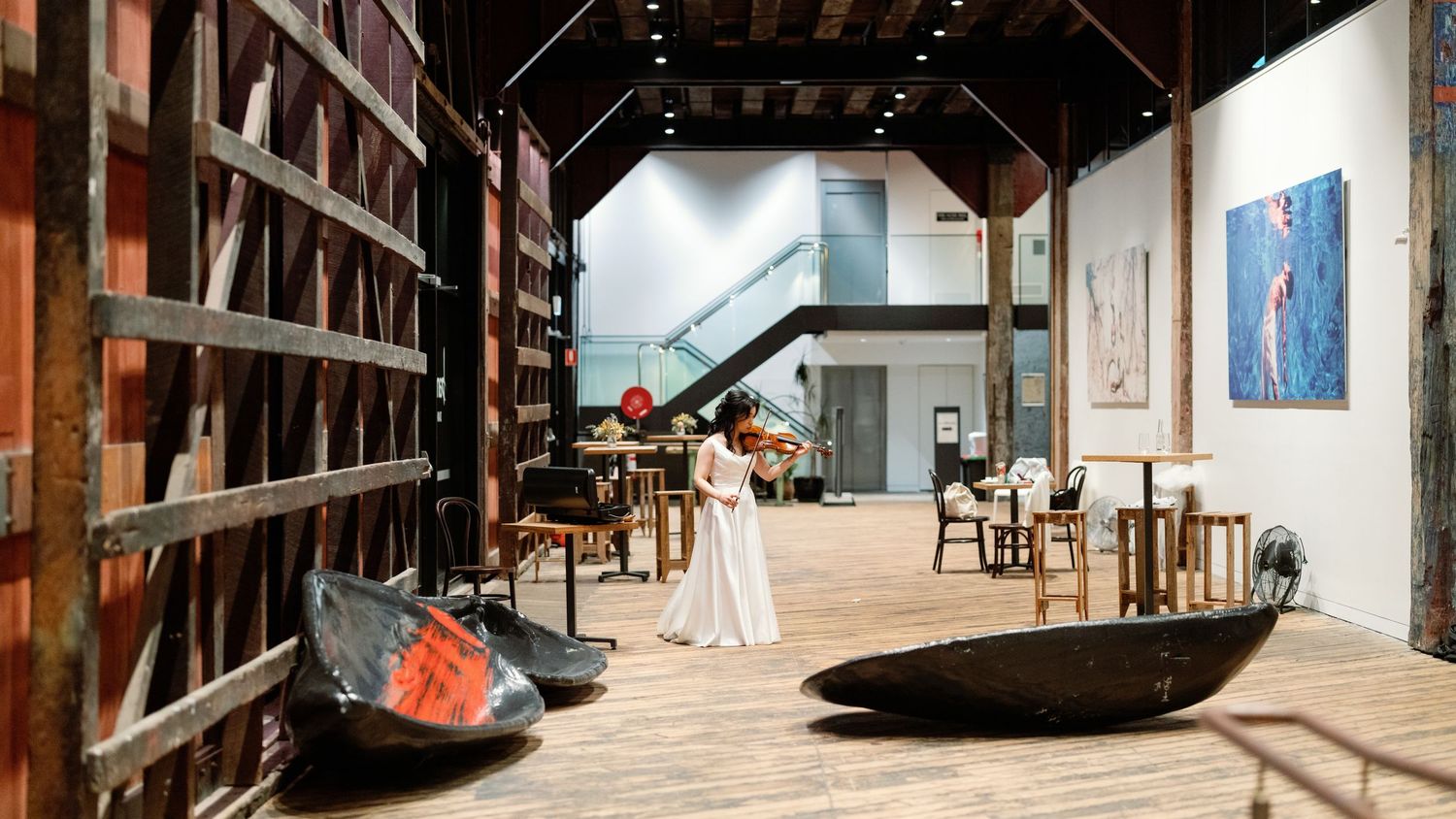 Interior view of rustic wooden barn or warehouse with high beamed ceilings and natural lighting.