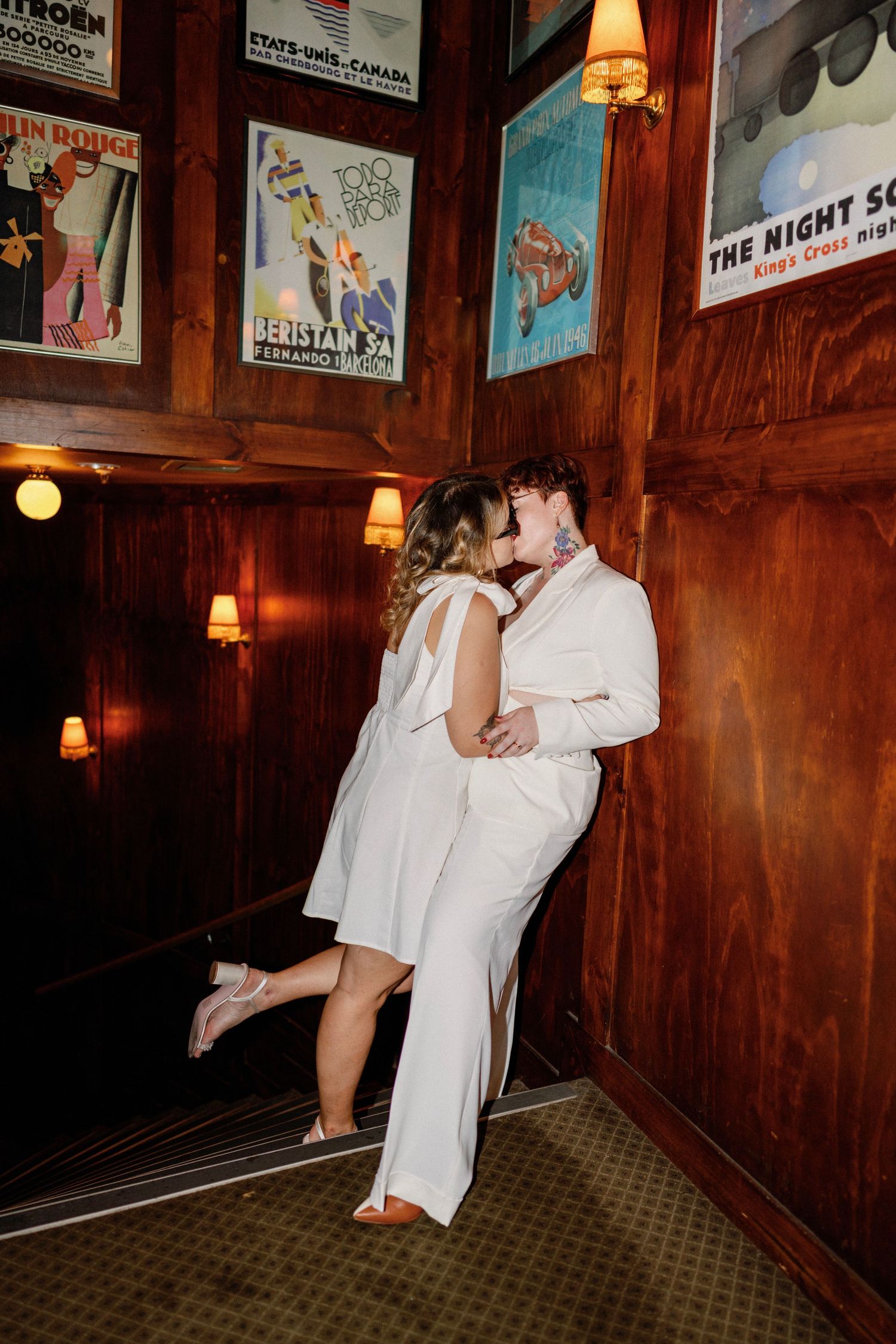 A romantic couple shares a dance in a vintage-style room decorated with retro posters and warm lighting.