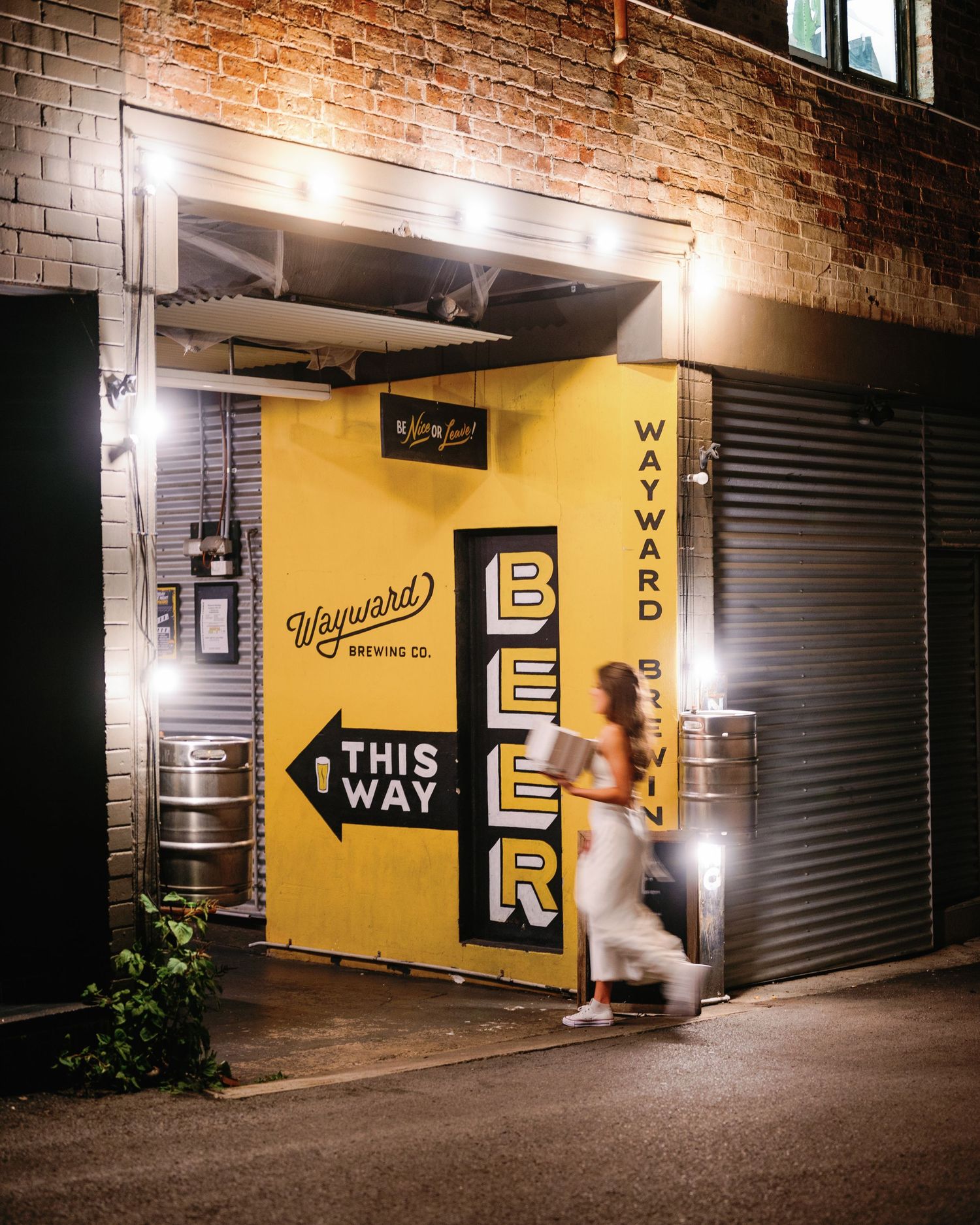 Yellow wall with directional signage and 'BEER' text in industrial corridor setting.