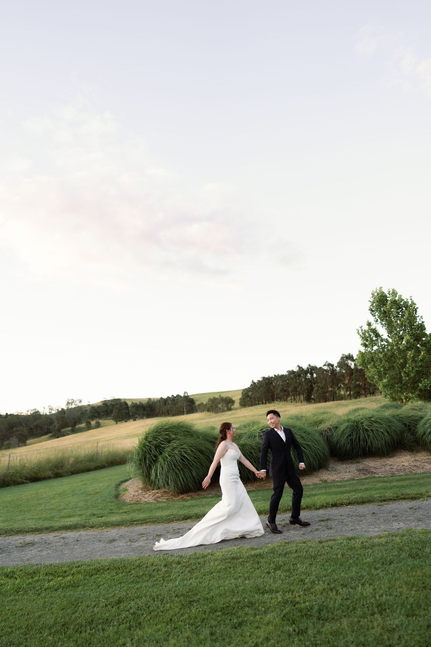 Romantic sunset wedding portrait on a hilltop with rolling landscapes in the background.
