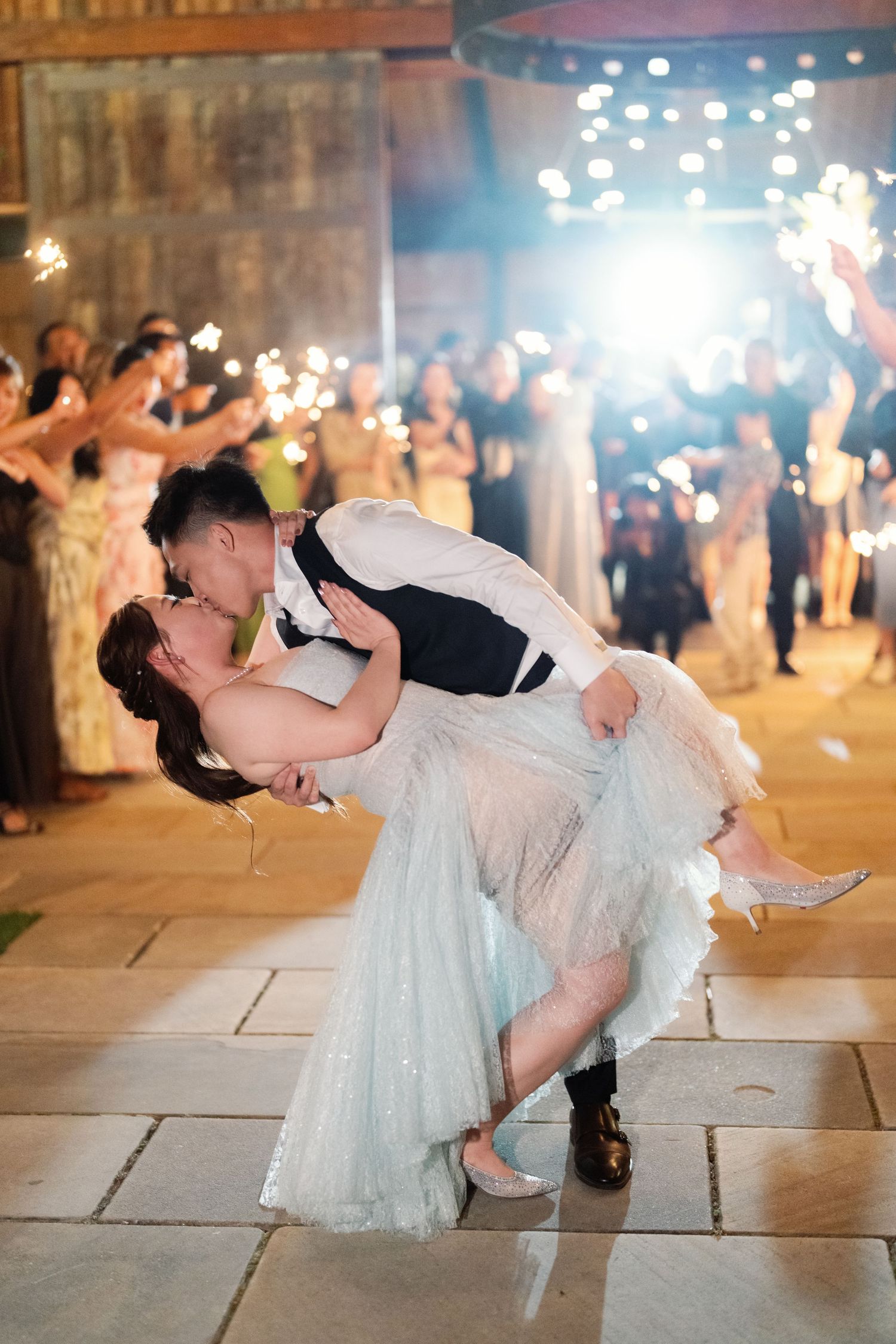 Couple performing romantic dance dip on stone floor at evening celebration.