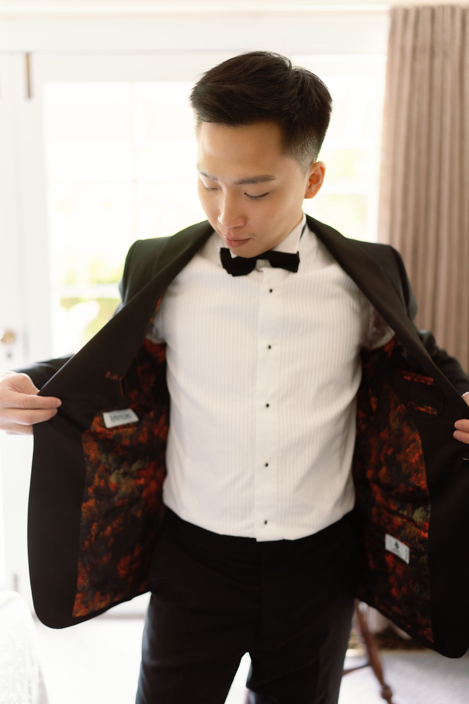 Groom adjusts his black and red patterned tuxedo jacket in sequence of preparation shots.