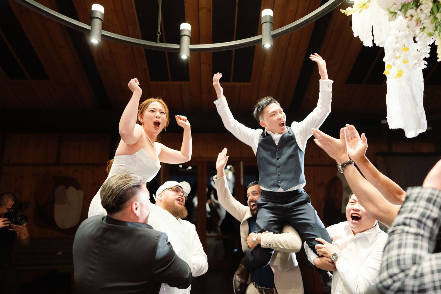 Celebration scene with guests cheering and raising arms in excitement.