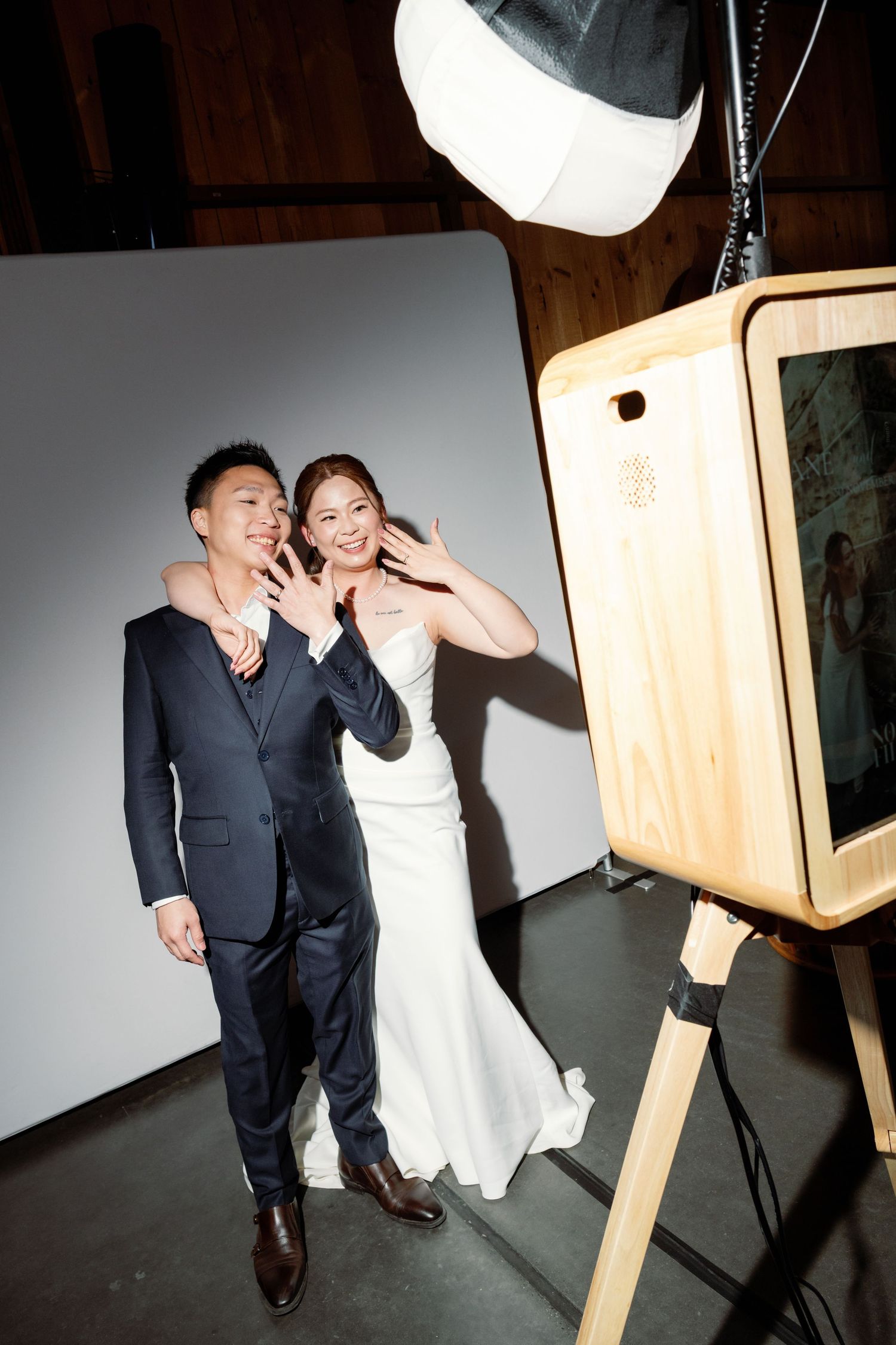 Couple poses together against studio lighting setup in formal attire.