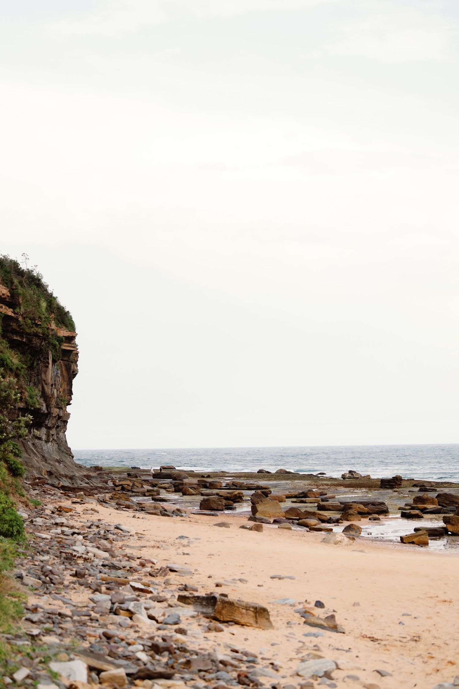Rocky coastal beach landscape with cliffs and ocean view.