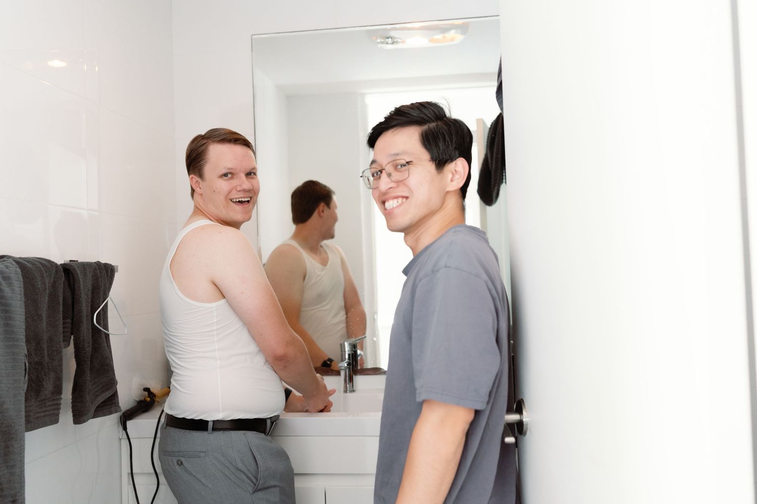 People in a white room trying on different outfits and discussing fashion choices while looking in mirrors.