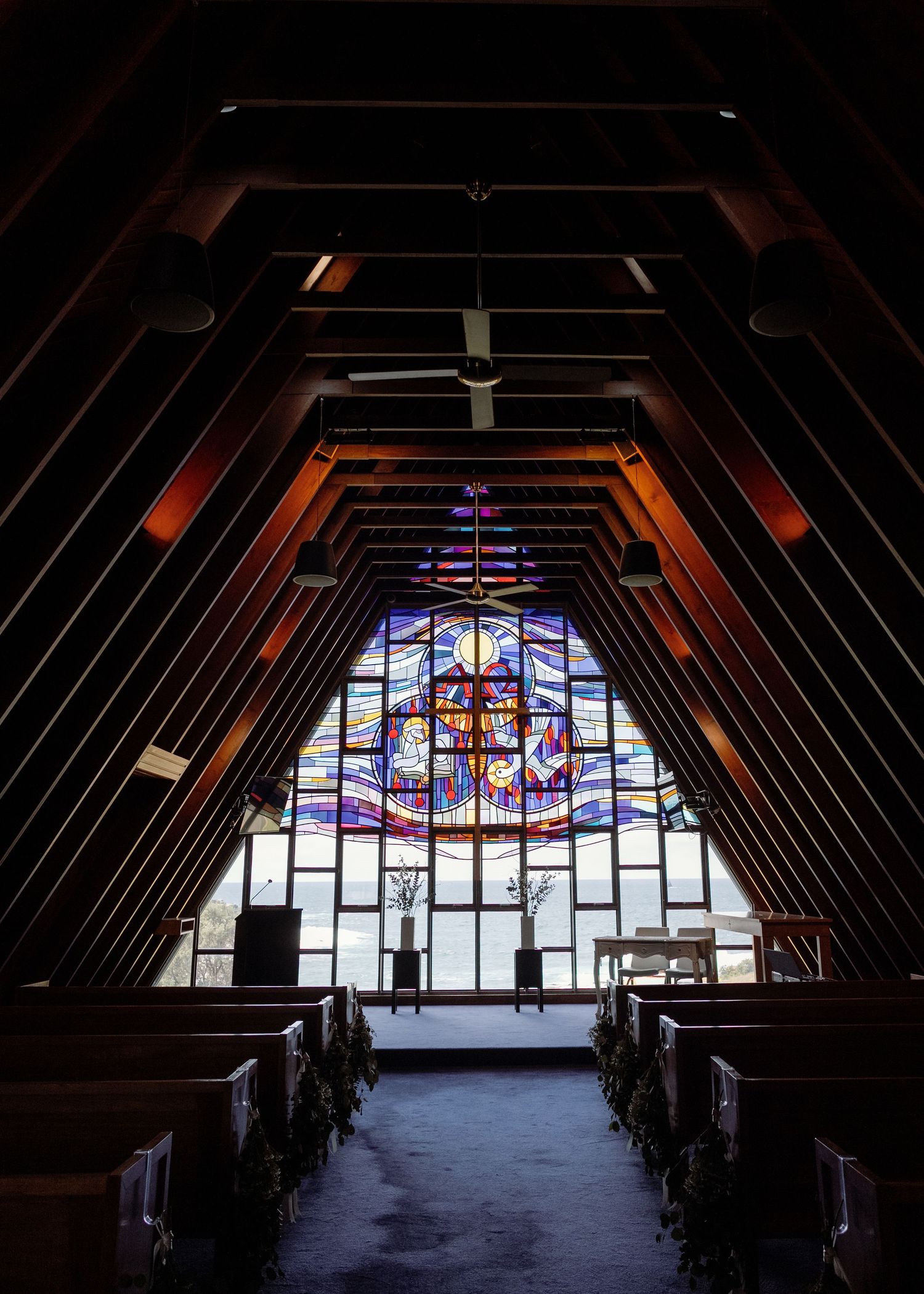A series of stained glass windows in a church attic space photographed at different times showing changing natural light.