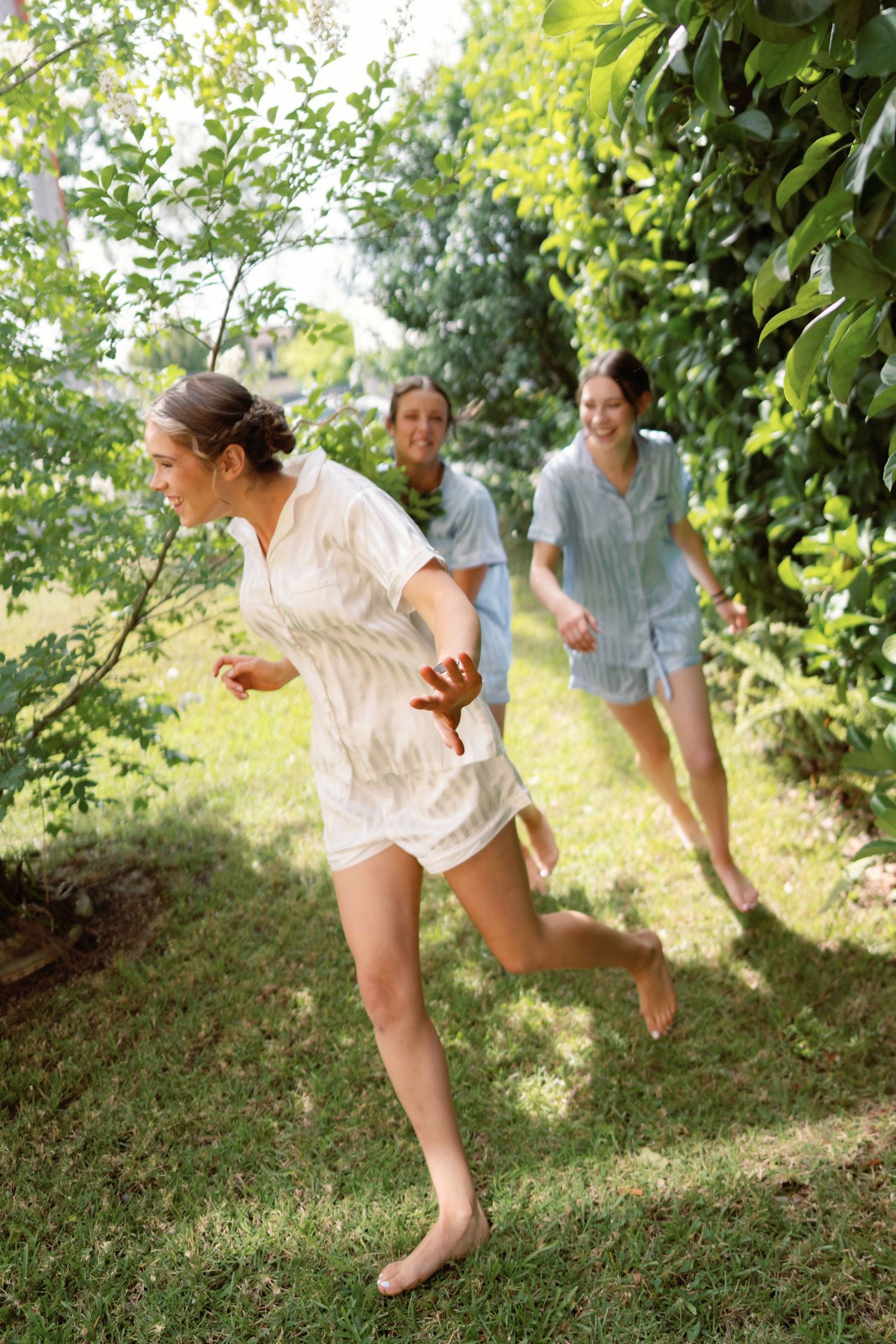 Playful group running through an orchard on a sunny summer day.