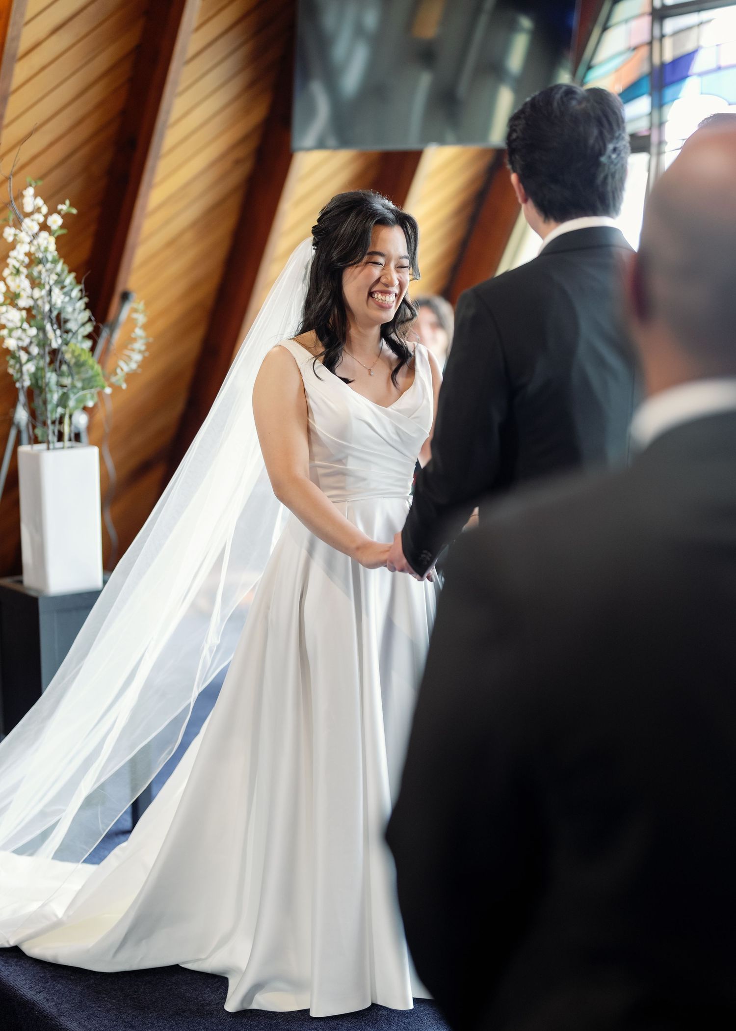 Bride in flowing white gown twirls and dances during wedding celebration.
