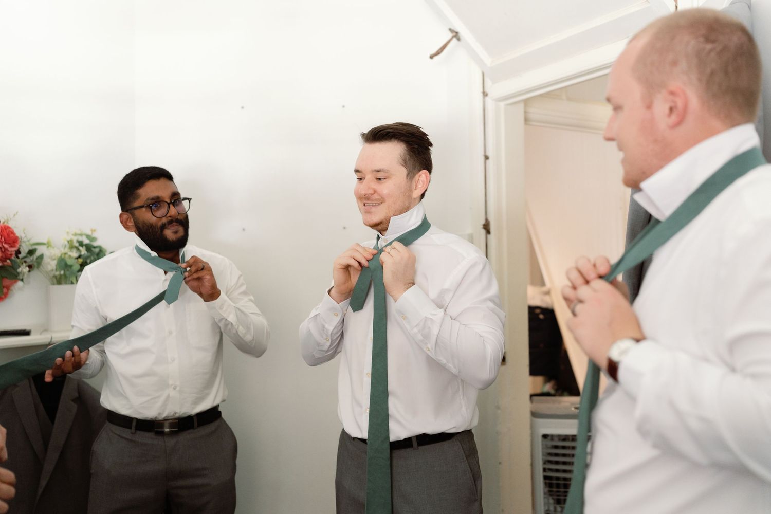 A sequence of photos showing a person in business attire loosening and removing a green necktie.