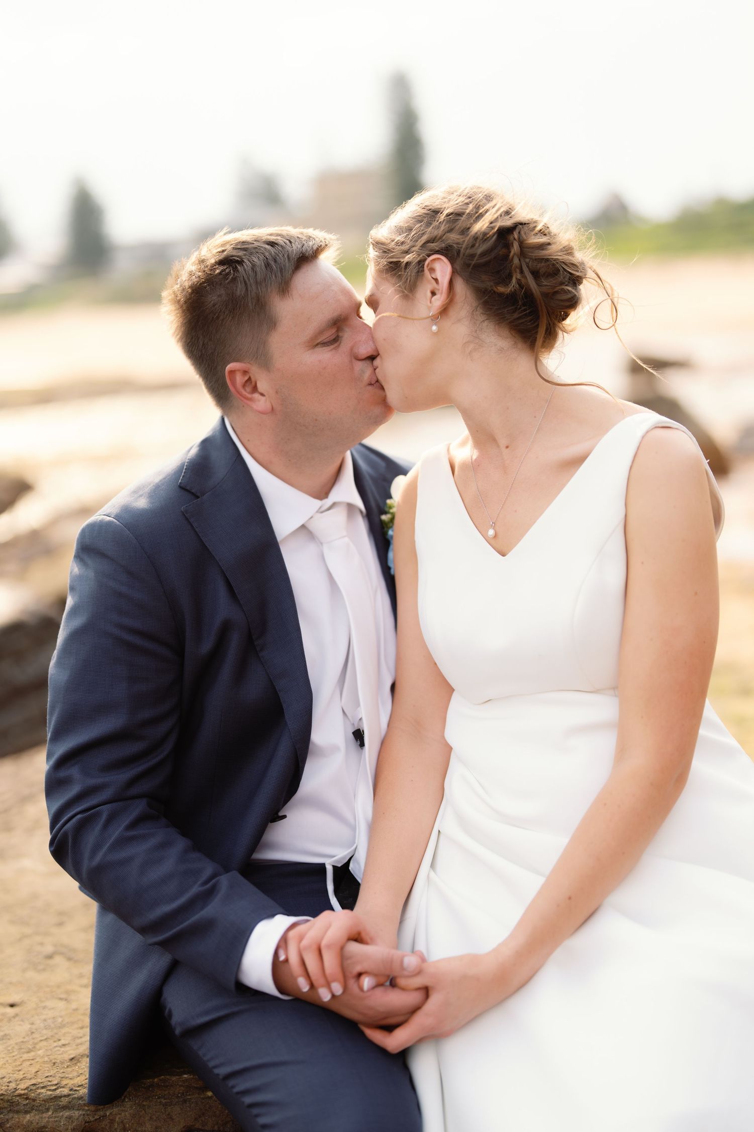 Romantic wedding couple shares intimate moments in formal attire by the waterfront.