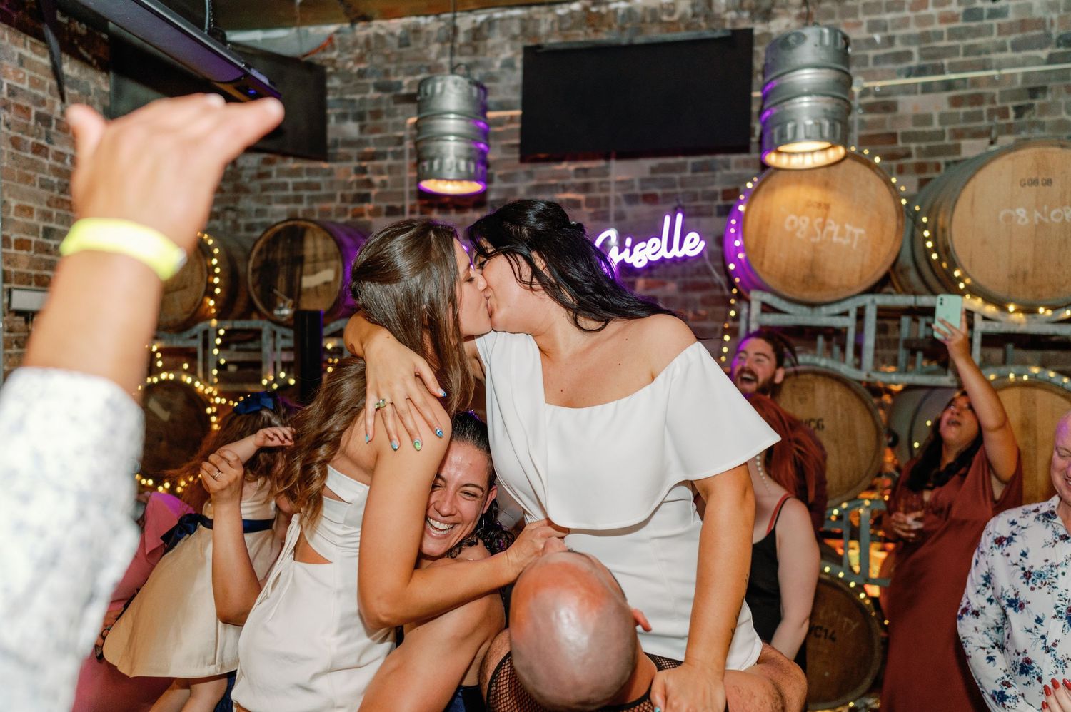 Bar interior with exposed brick walls and decorative lighting during evening event.