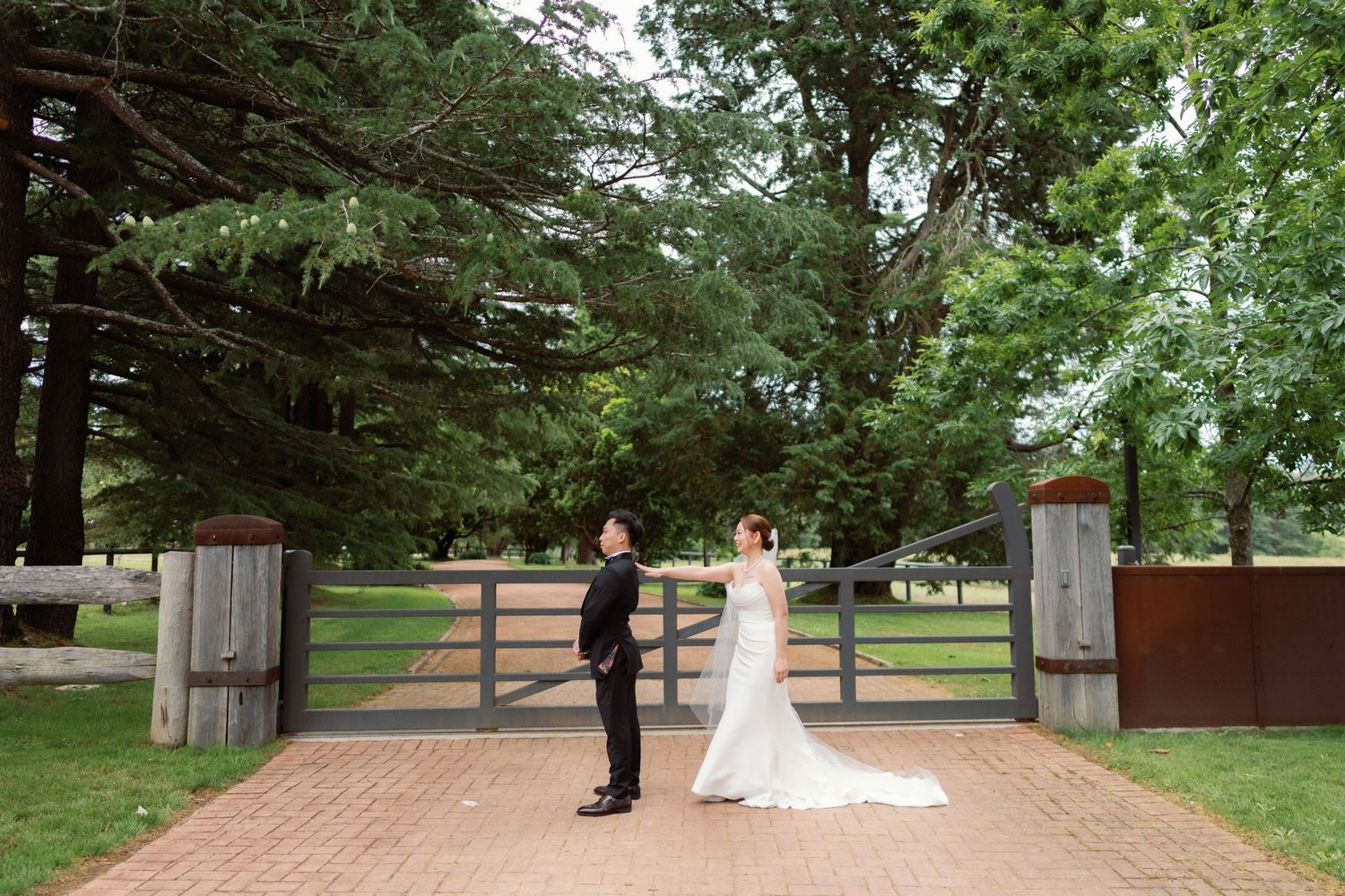 A romantic outdoor wedding ceremony setup with wooden posts and greenery in a rustic garden setting.