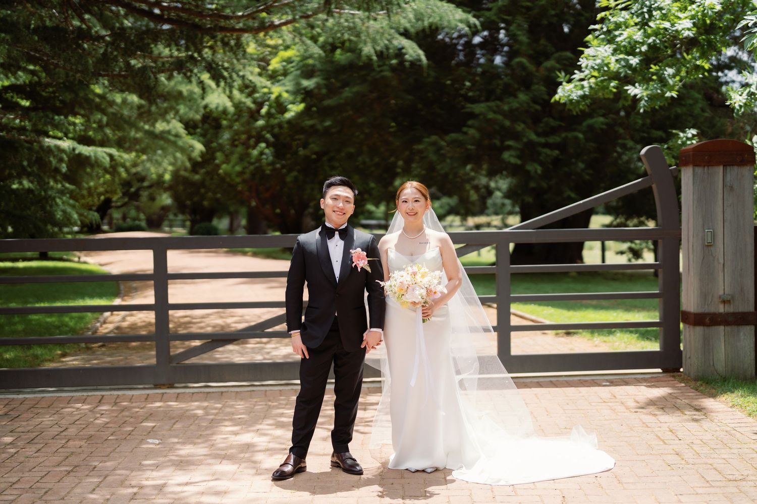 A couple in wedding attire walks together through a lush garden path on their special day.