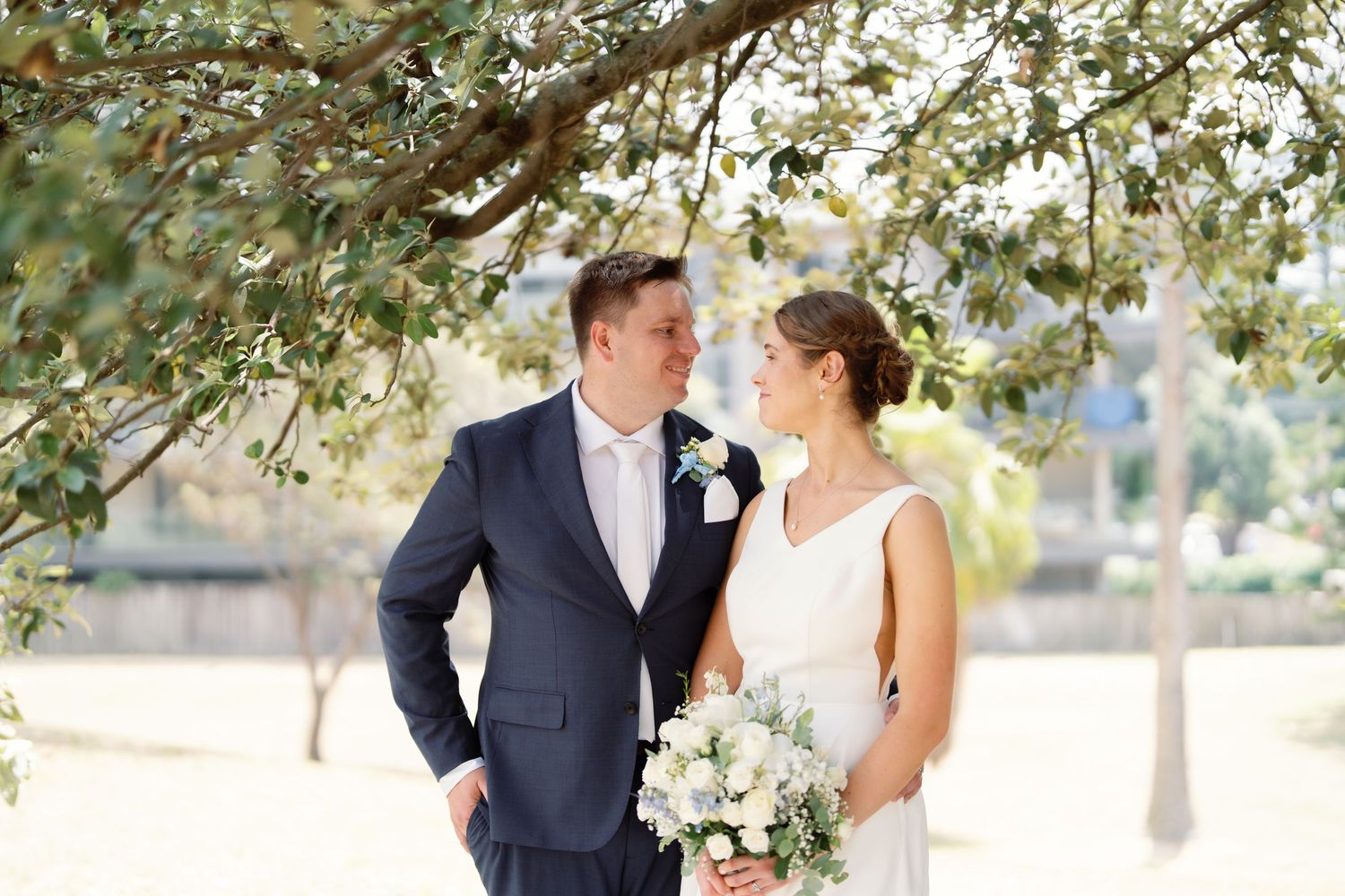 Elegant outdoor wedding photography session under natural tree canopy.