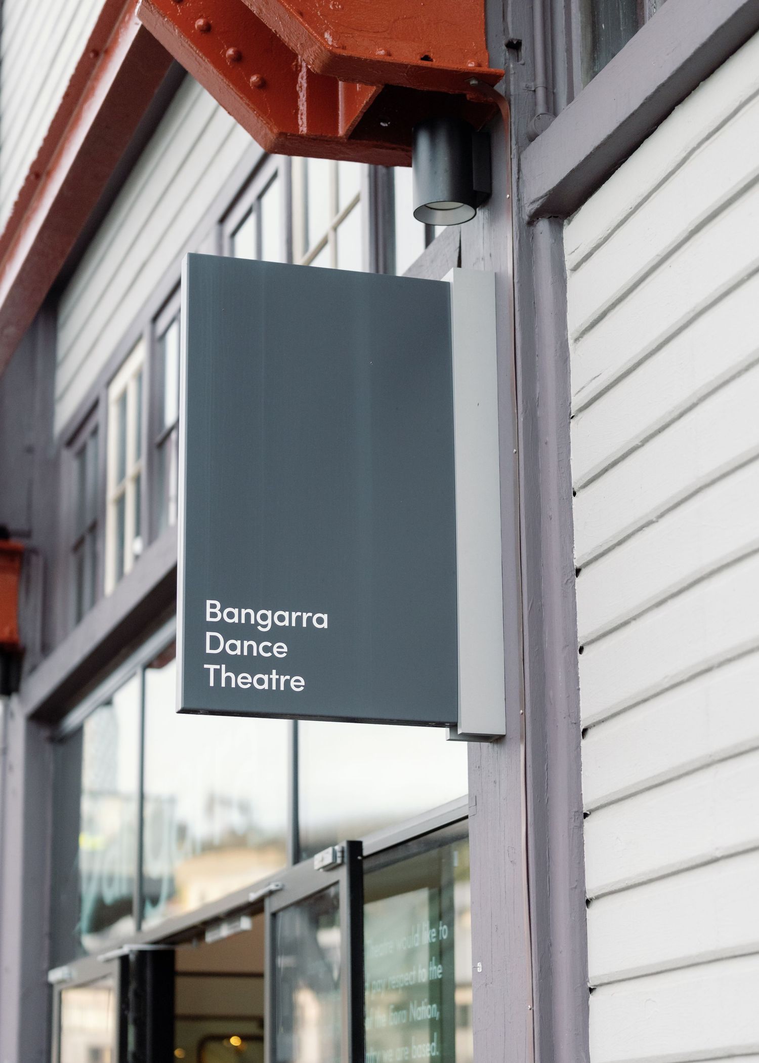 Modern white building facade with minimalist signage for Dance Theatre and Bangarra performance spaces.