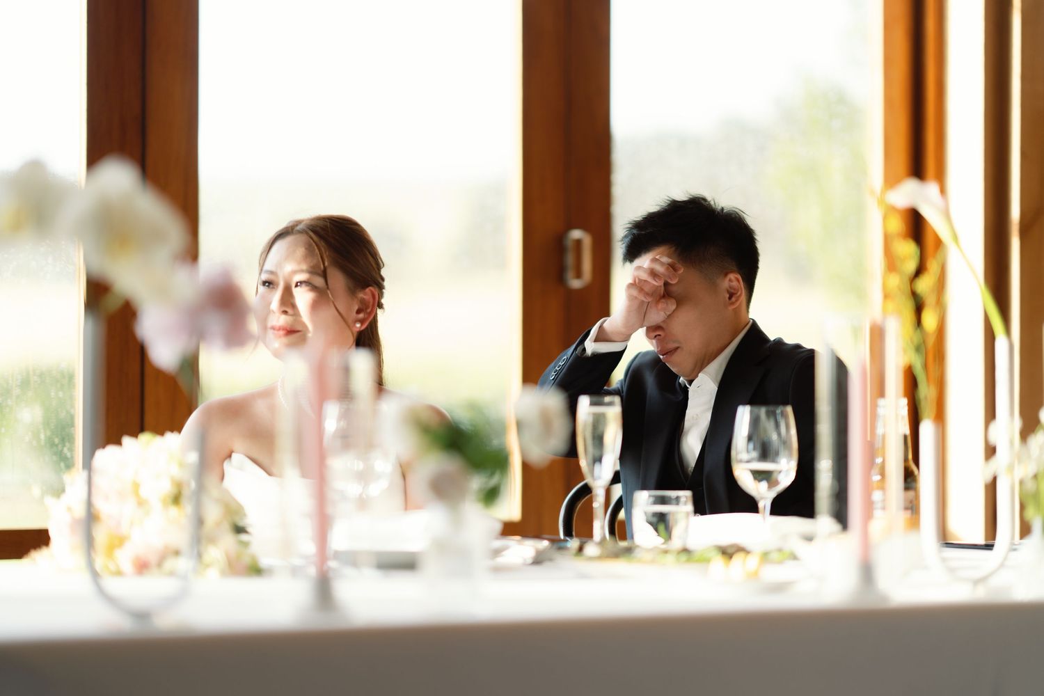 Elegant wedding reception venue with natural light streaming through large windows.
