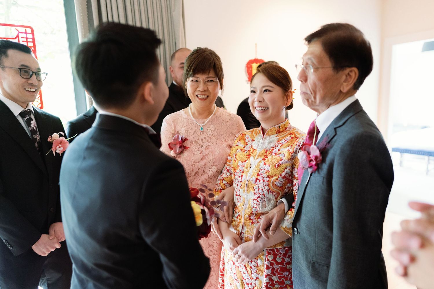 Wedding ceremony guests in formal attire gather and celebrate in an indoor venue.