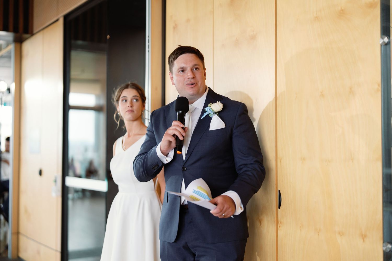Groomsmen in navy suits gathered for candid moments during wedding celebration.