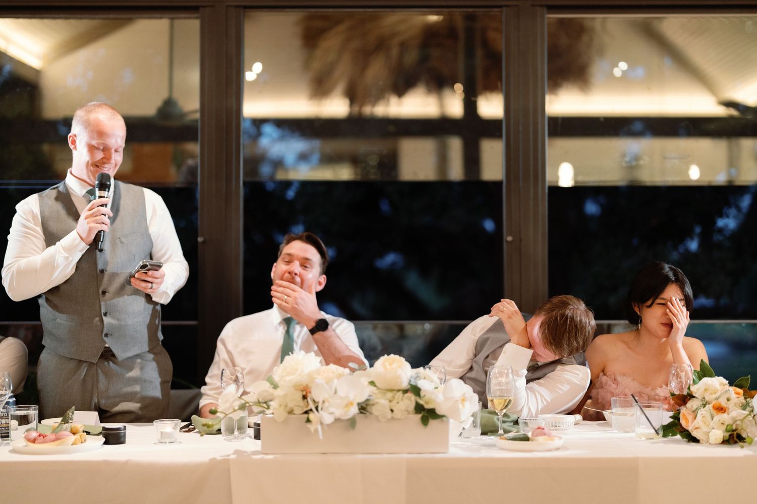 Wedding reception dinner tables set with white linens and floral centerpieces.