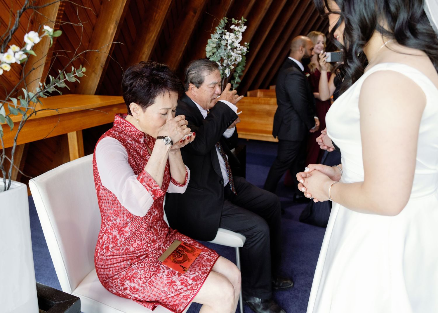 Wedding ceremony proceedings inside a church with wooden architectural details.