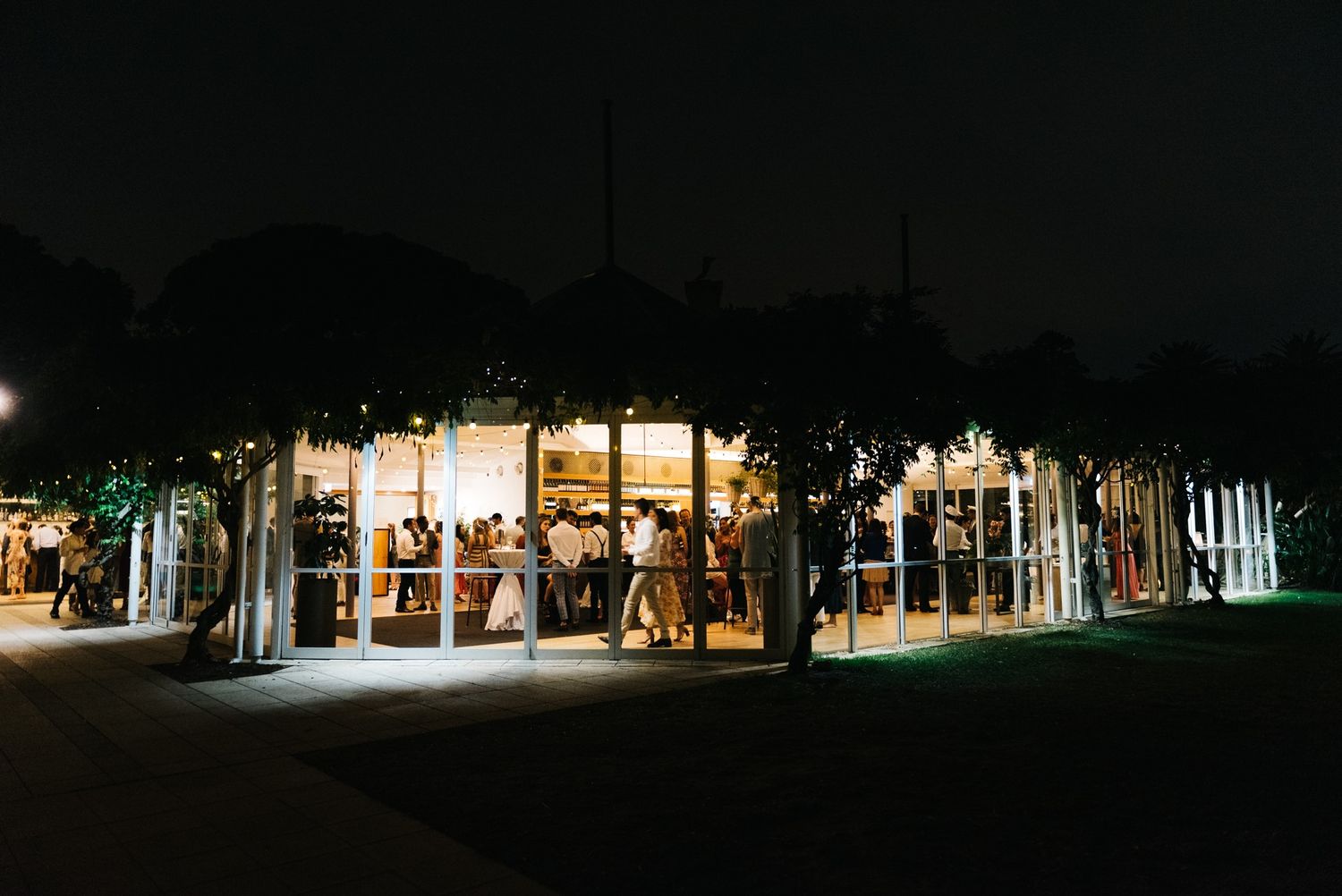 Outdoor venue lit up at night with string lights creating a warm, festive atmosphere.