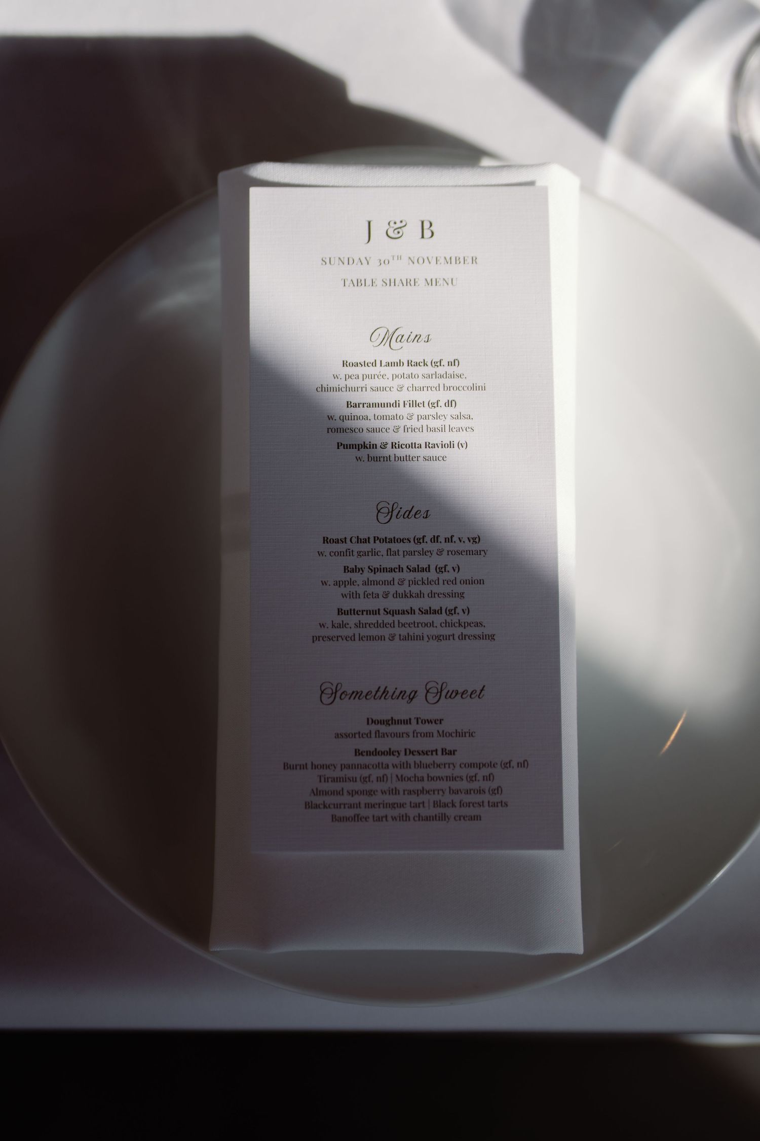 Wedding menu card with elegant typography photographed in dramatic lighting.