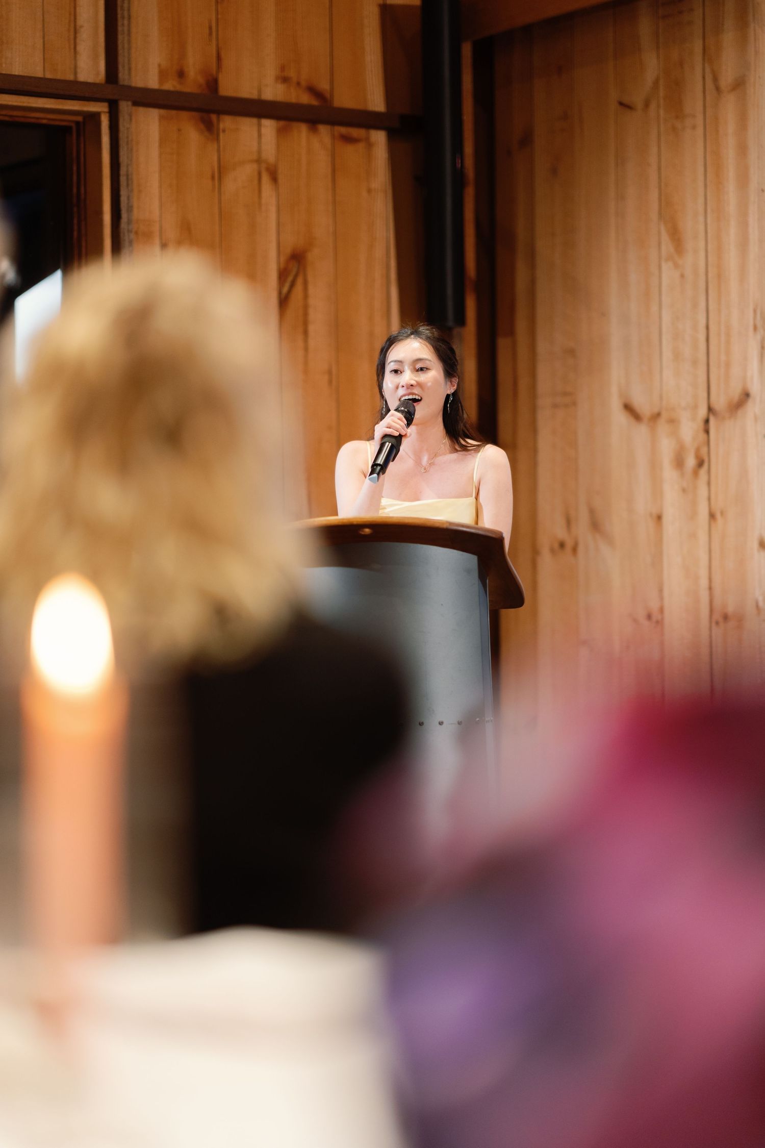 A sequence of candid reactions during wedding speeches in a wooden-paneled reception venue.