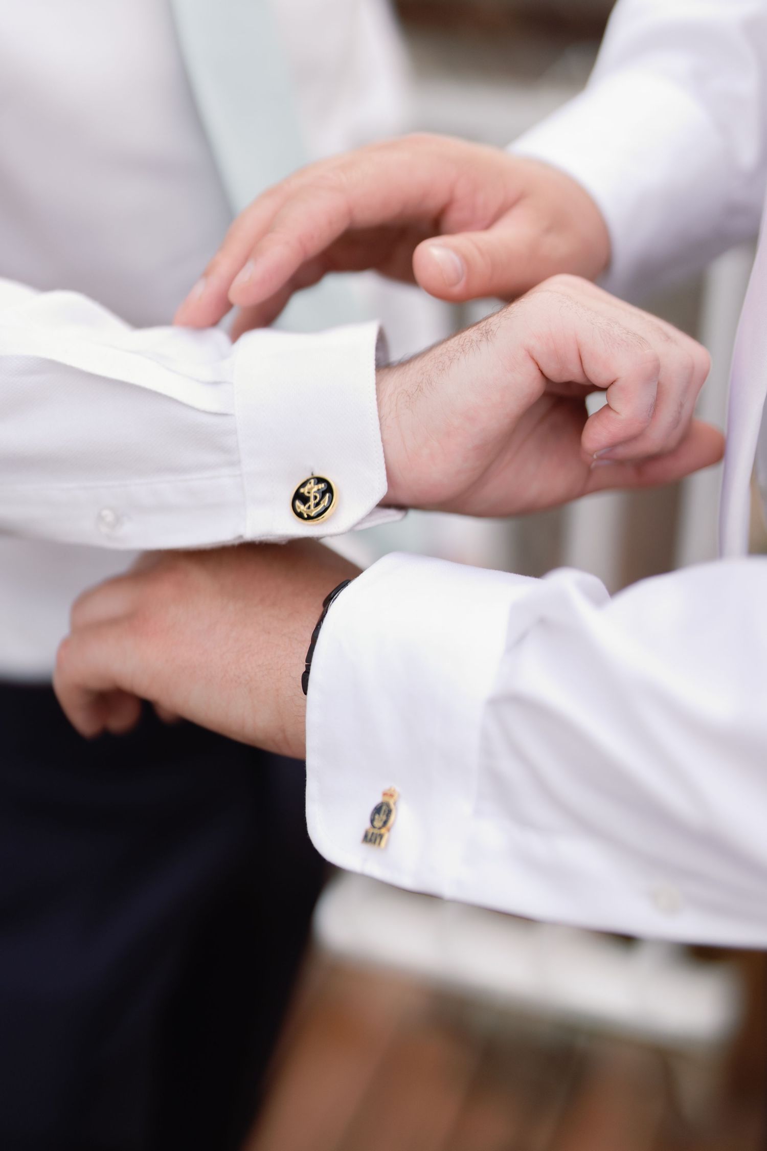 Close-up shots of hands adjusting white dress shirt cuffs with gold cufflinks.