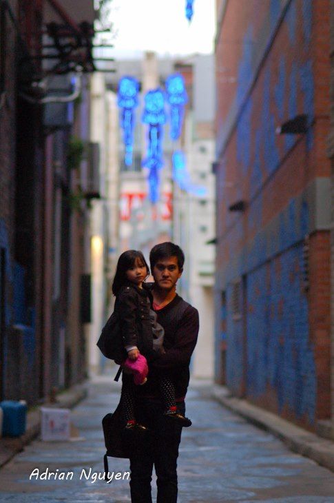 Urban alleyway scene with blue tinted lighting and brick buildings.