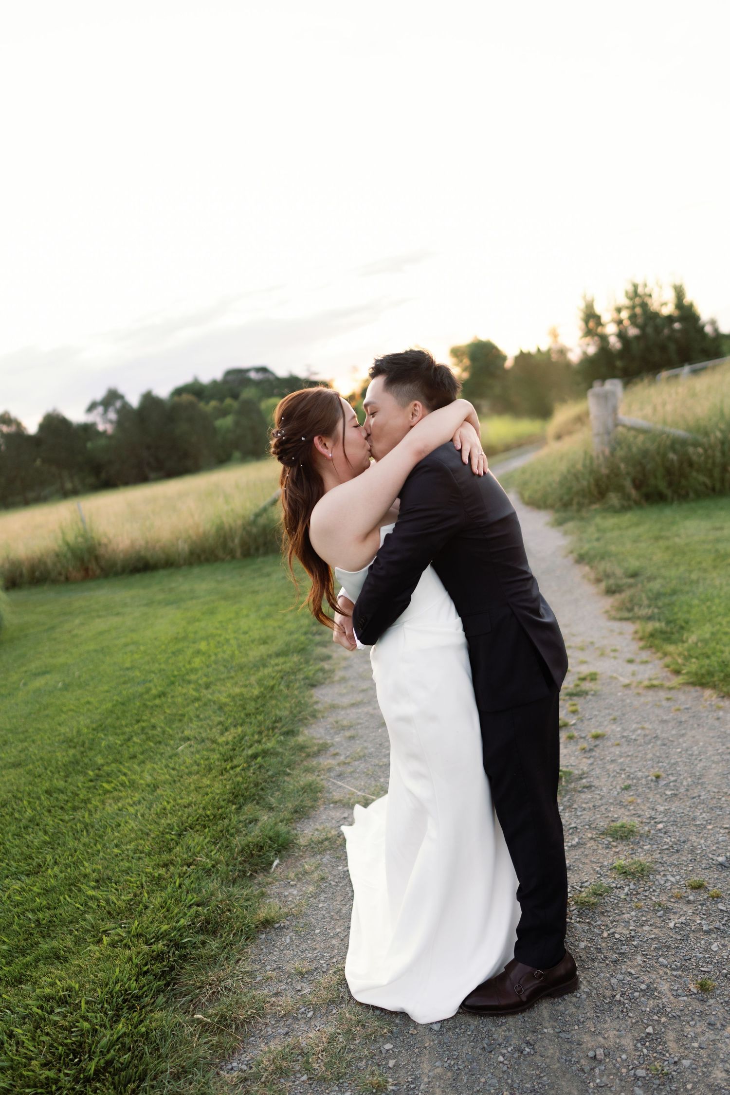 A romantic moment shared between a couple on a country path at dusk.