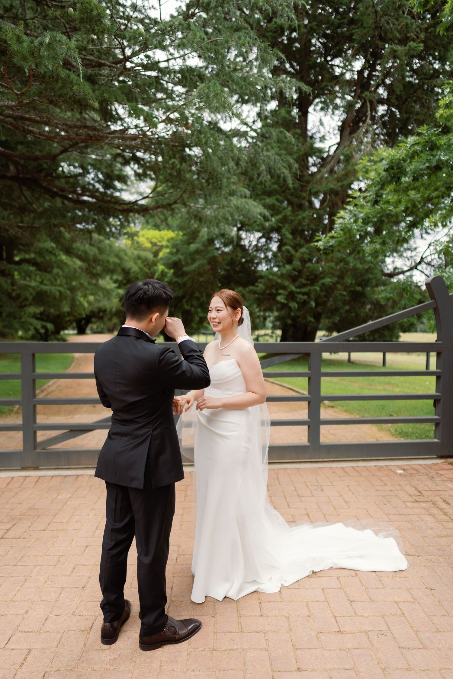 A couple performs a playful dance sequence on a brick patio surrounded by lush greenery.