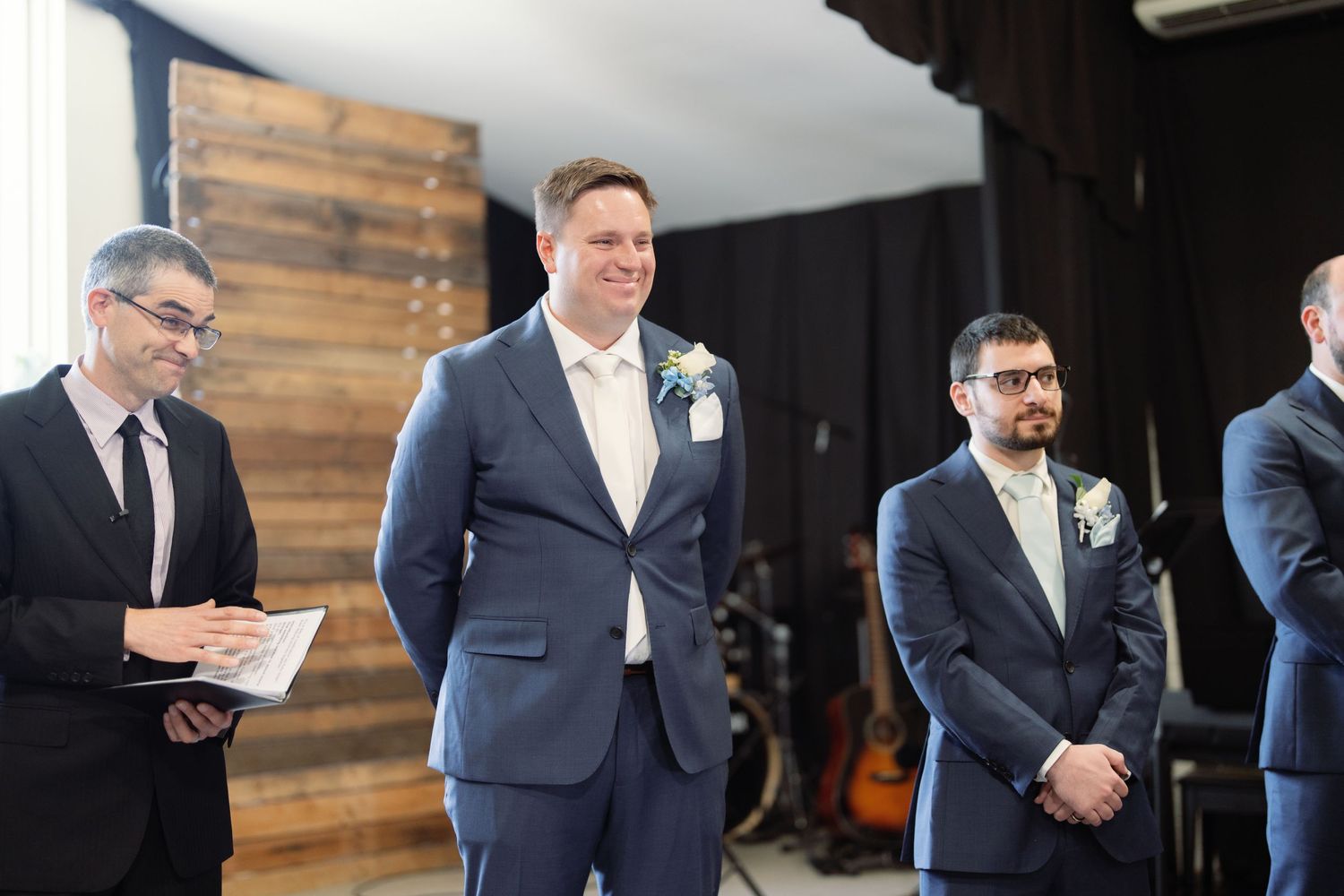 Business professionals in navy suits stand together during a formal corporate event.