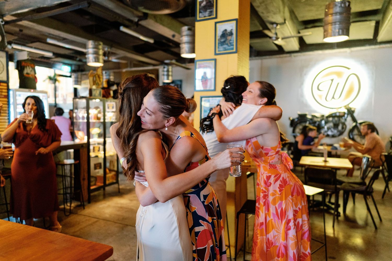 Wedding reception in a casual restaurant setting with exposed ceiling and industrial decor.