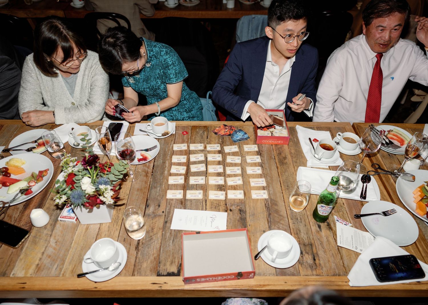 Wedding reception table settings on rustic wooden tables with place cards.