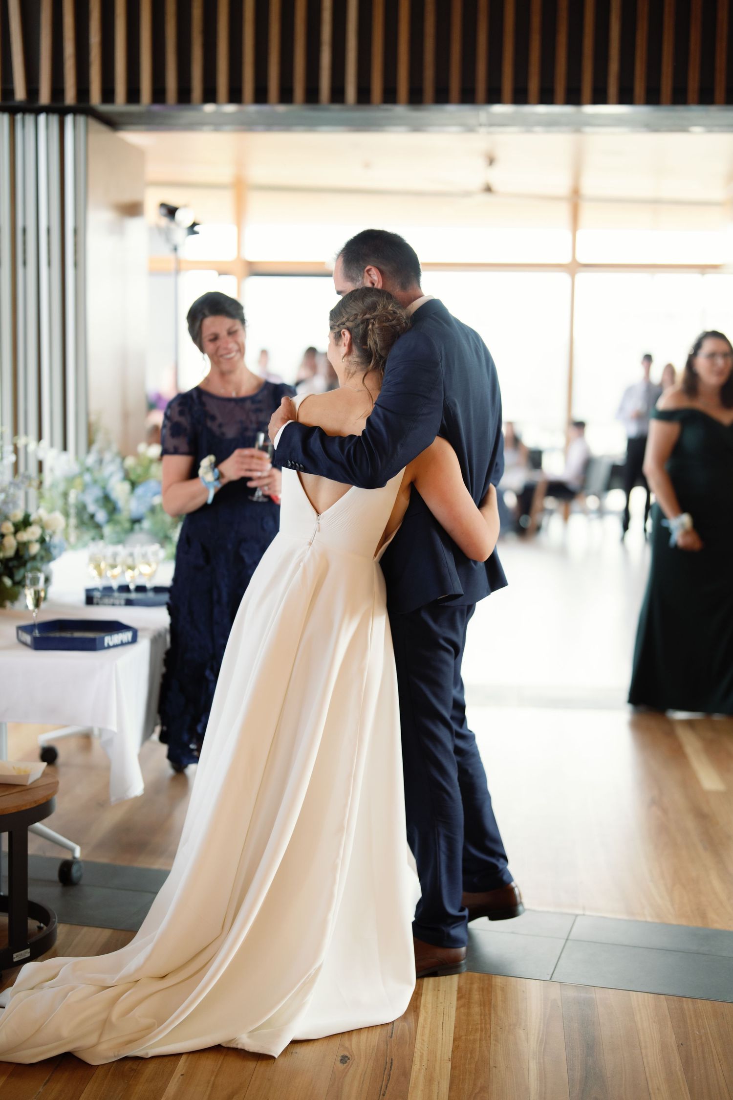A sequence showing a couple dancing together in an elegant indoor venue with wooden floors.