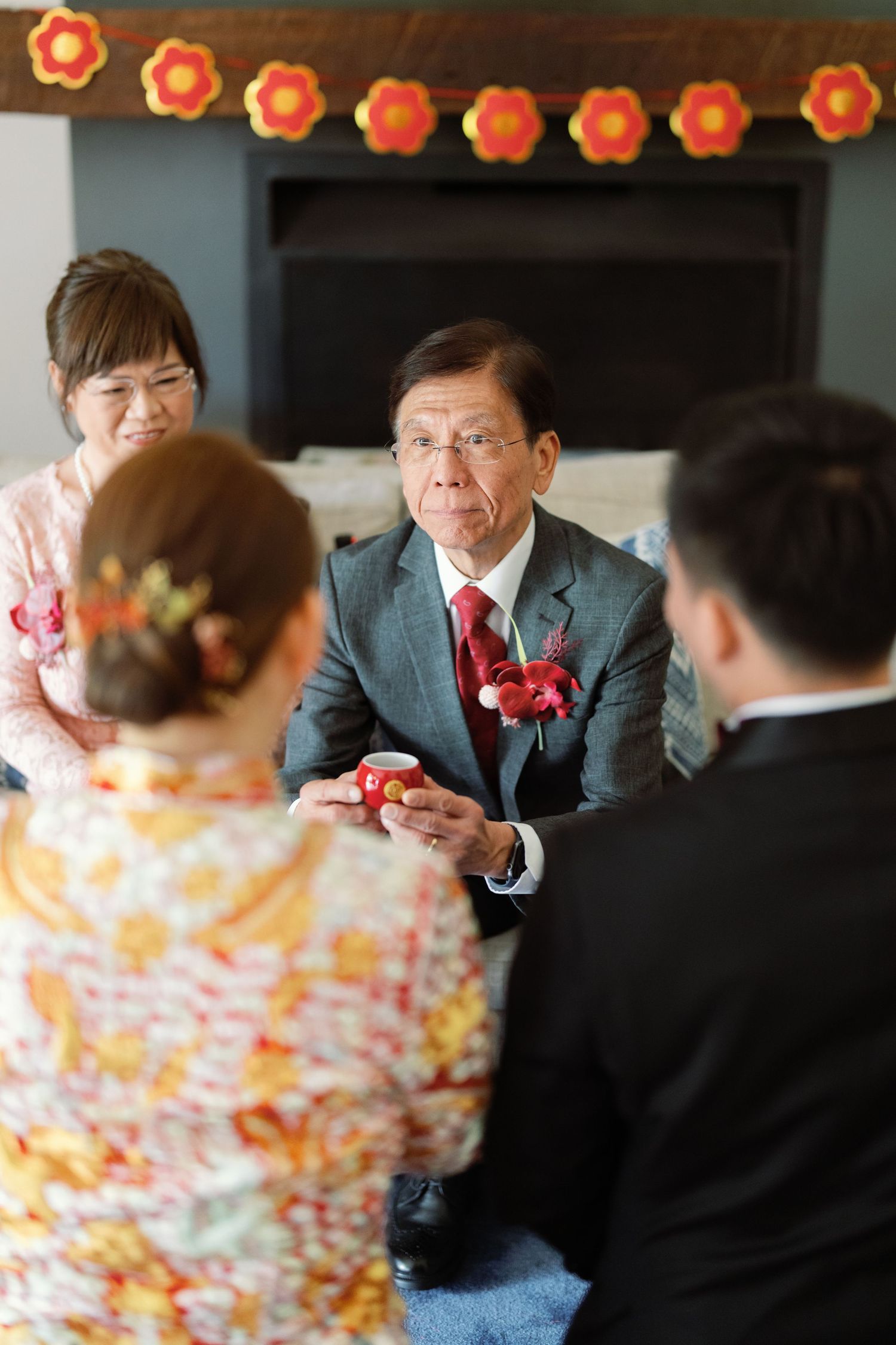 Wedding celebration with orange paper lantern decorations and guests gathered at tables.
