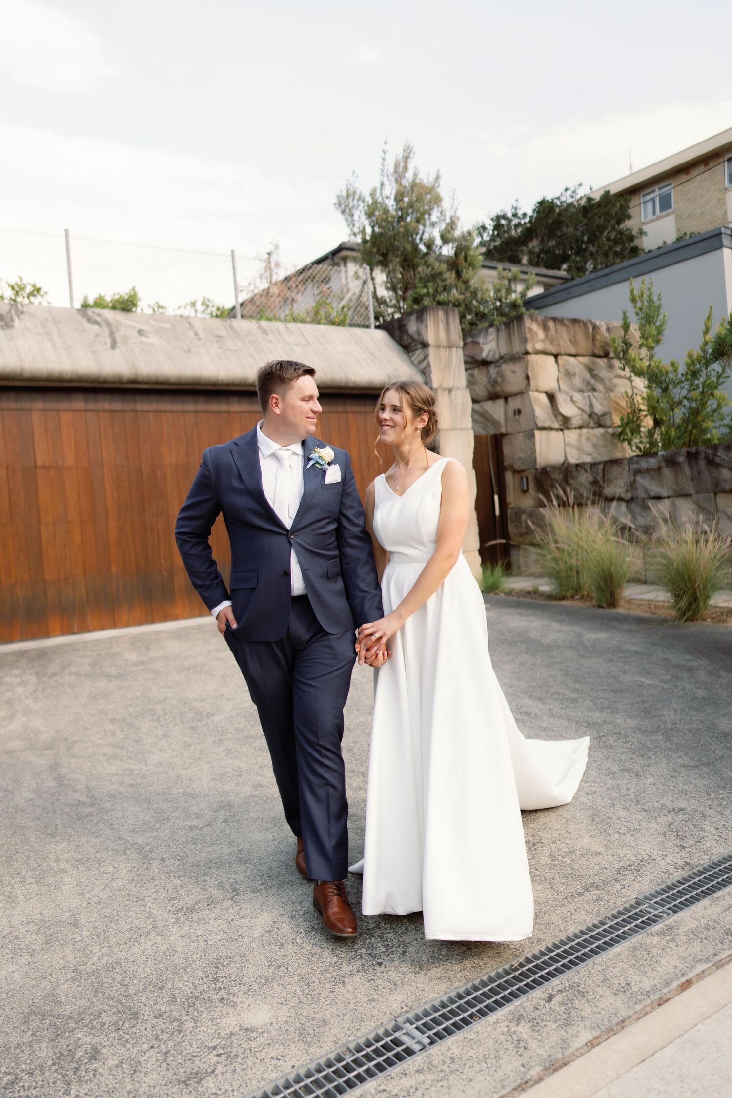 A series of candid wedding photos showing a couple walking together on a gravel path.