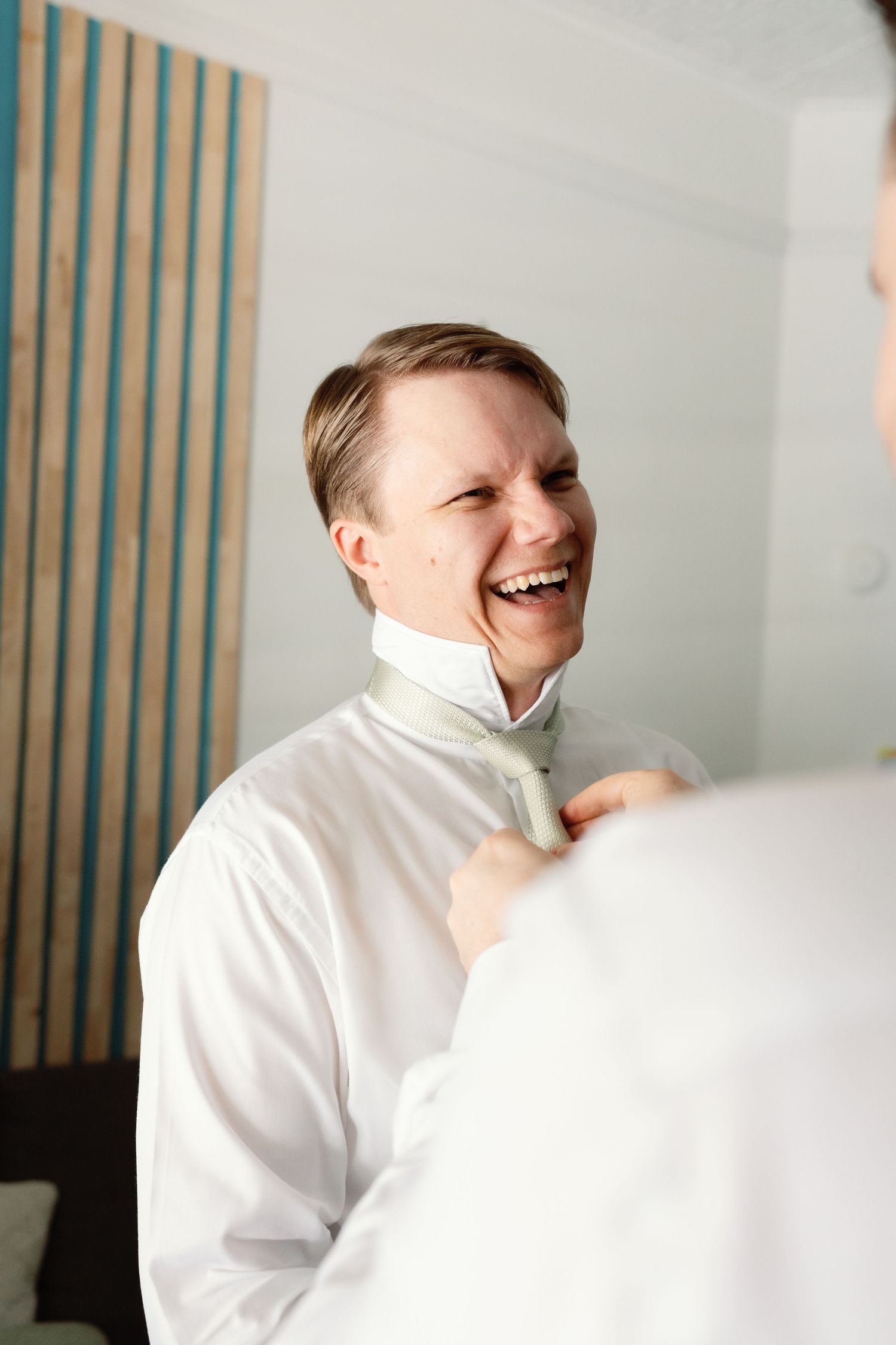 A series of candid laughing moments captured in white attire against a light background.