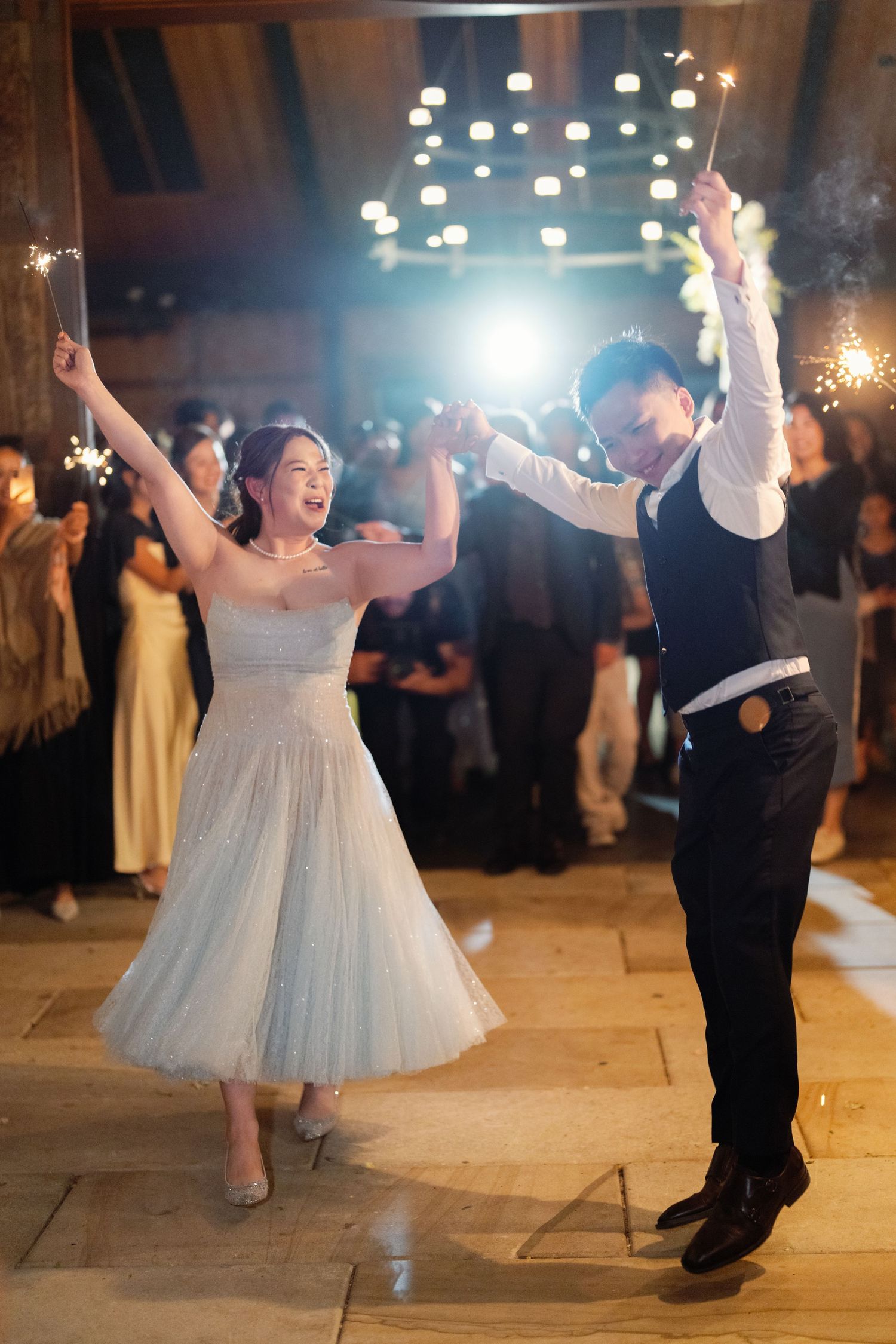Wedding celebration with dancers in formal attire under sparkling lights.