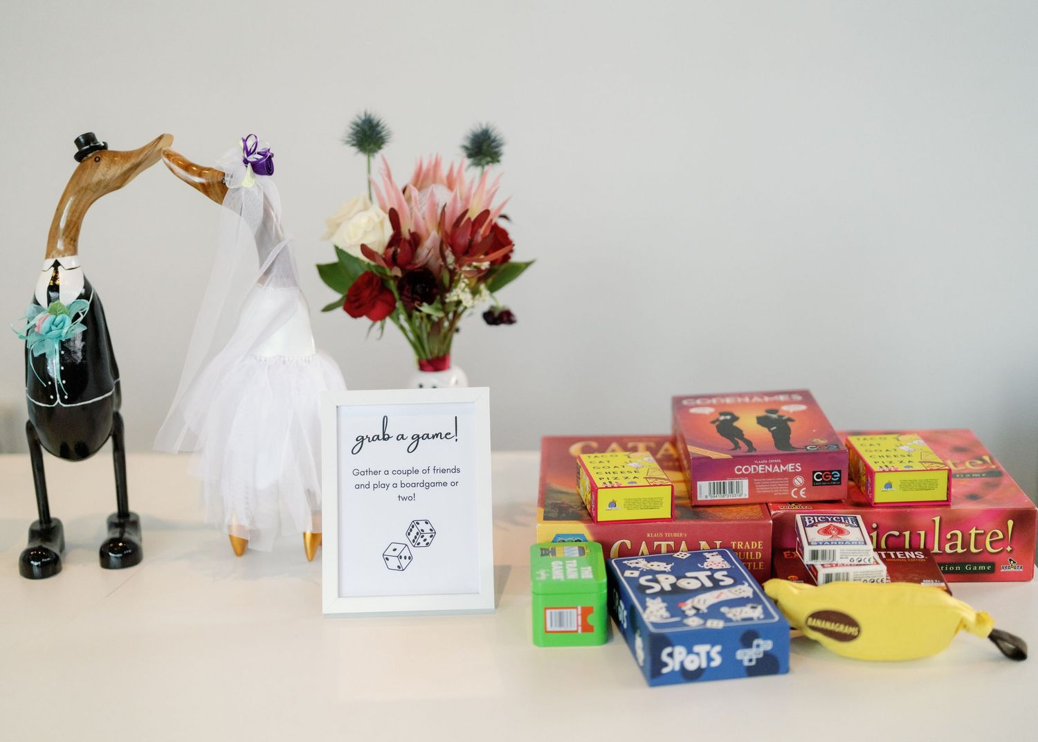 Collection of board games and party supplies arranged on white table.