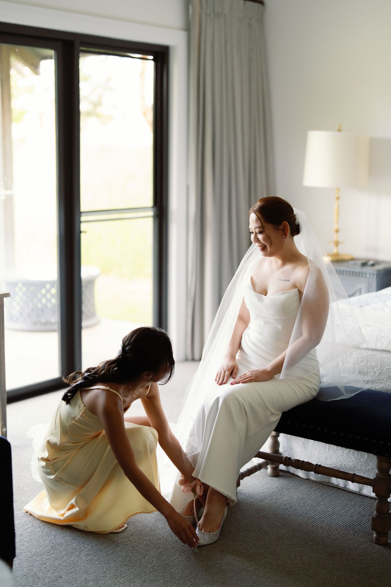 Getting ready scene with white dress and natural window light in modern room.