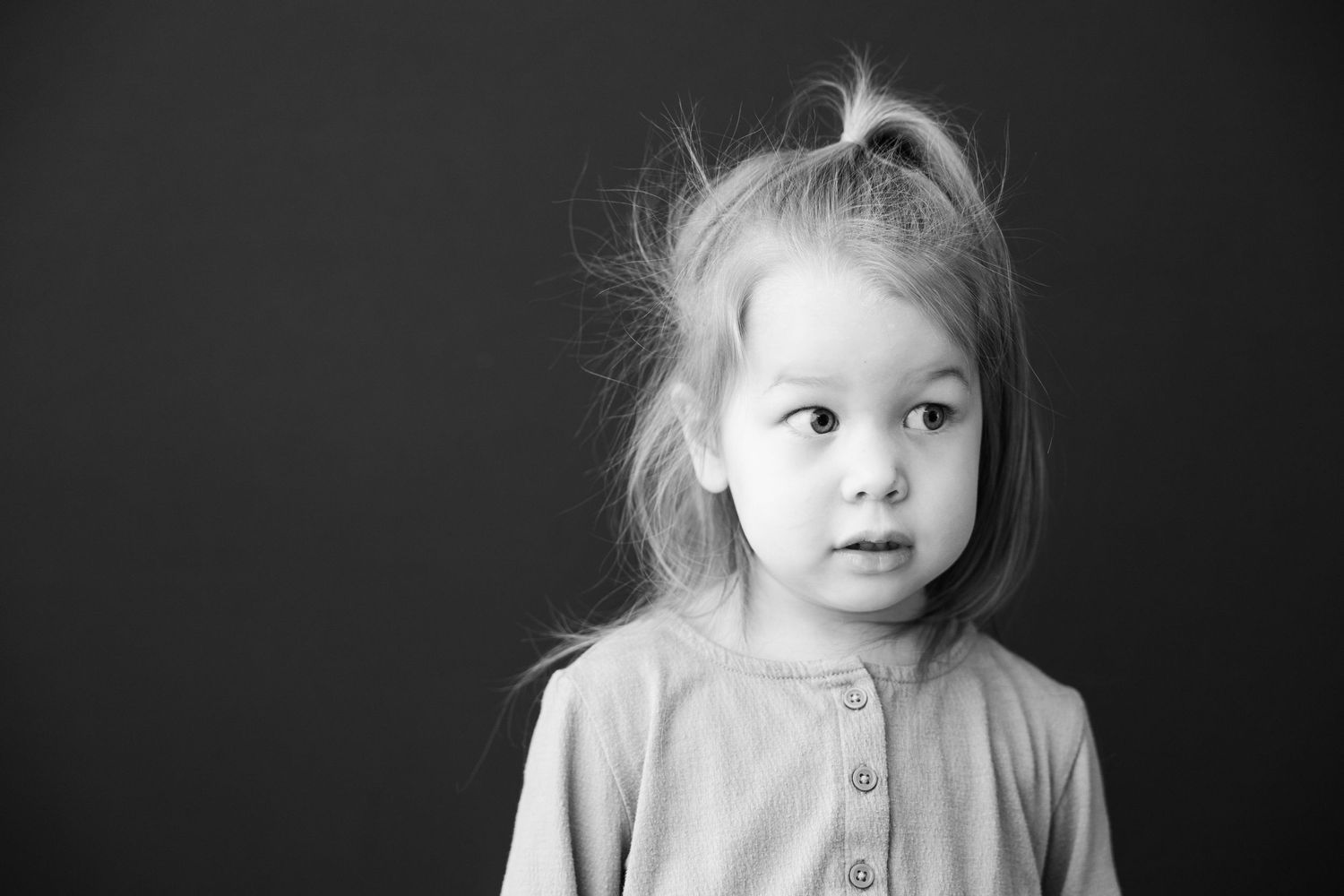 Black and white portrait photography collage showing the same child at various angles with different expressions and poses.