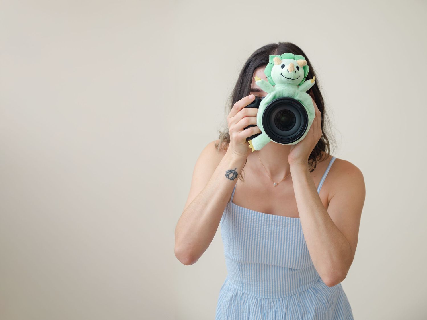 A series of self-portraits showing a photographer with a digital camera in light blue attire.