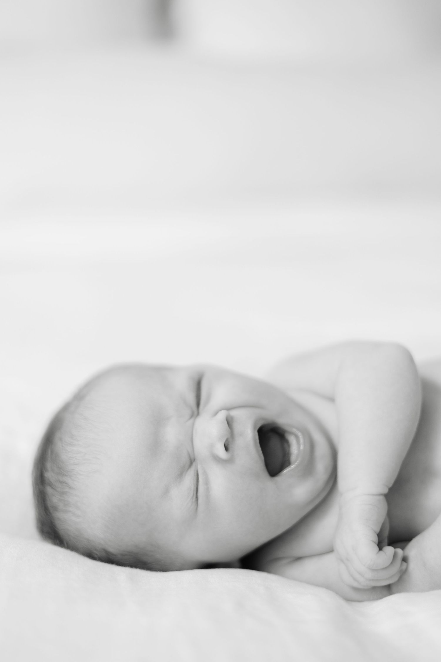 A peaceful black and white image of a sleeping baby in profile against a light background.