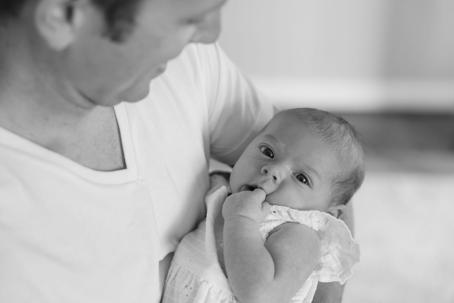A black and white photo montage showing tender moments between a parent and baby in various poses.