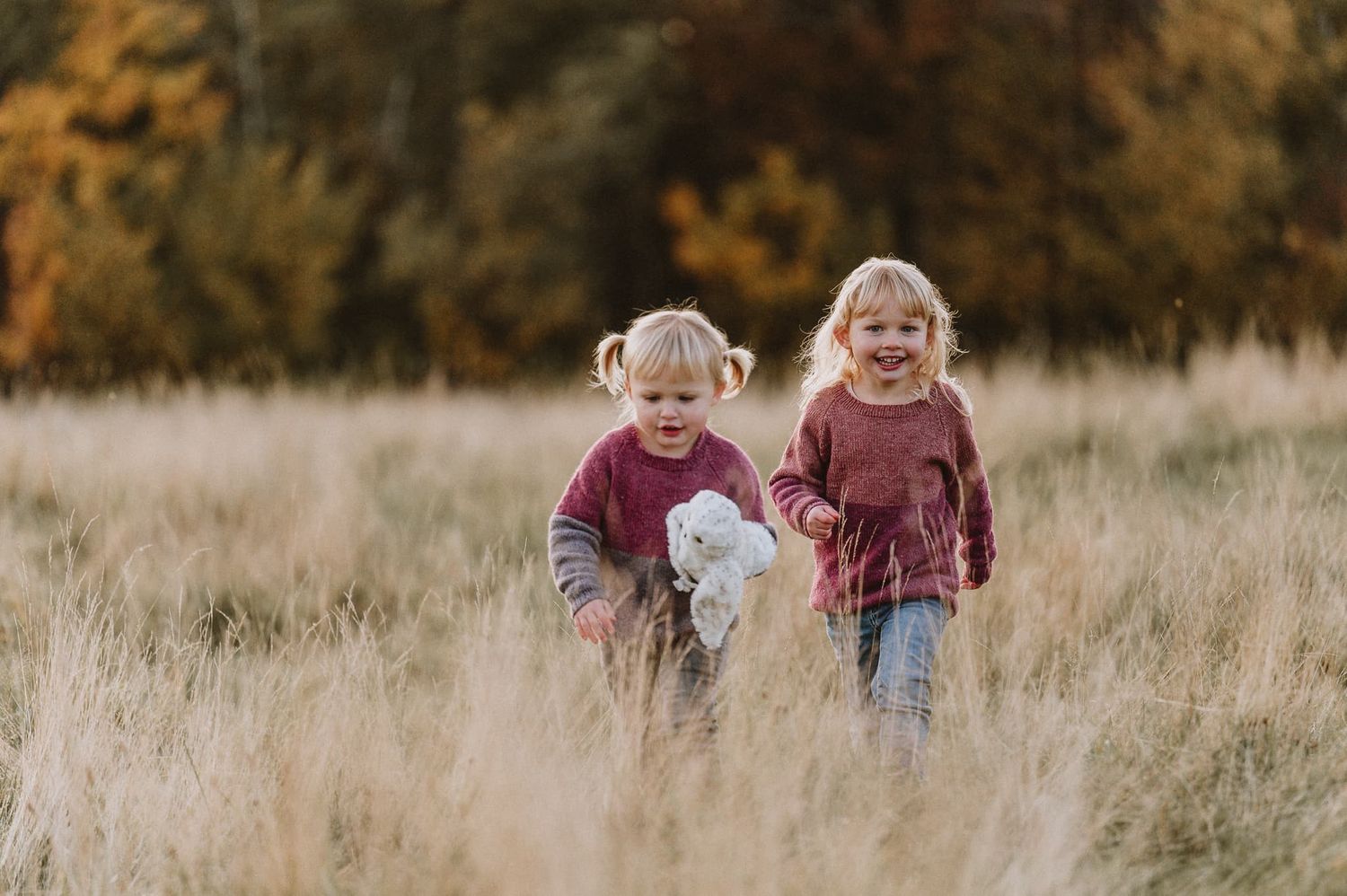 Flickor går på en äng på hösten, vid en avslappnad familjefotografering i Jönköping, med Fotograf Veronica Eng, Mullsjö.