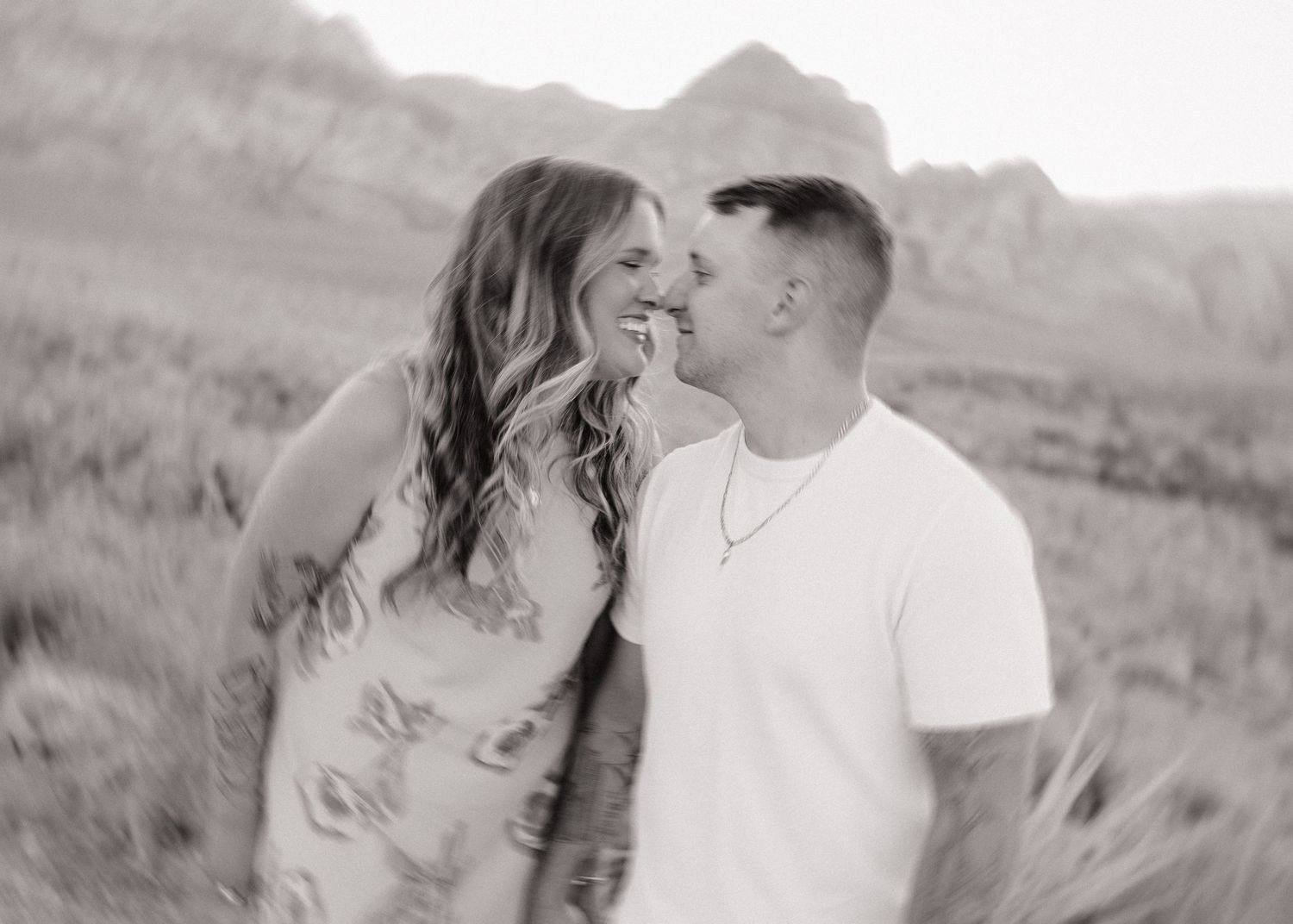 Romantic black and white portrait in front of mountain landscape.